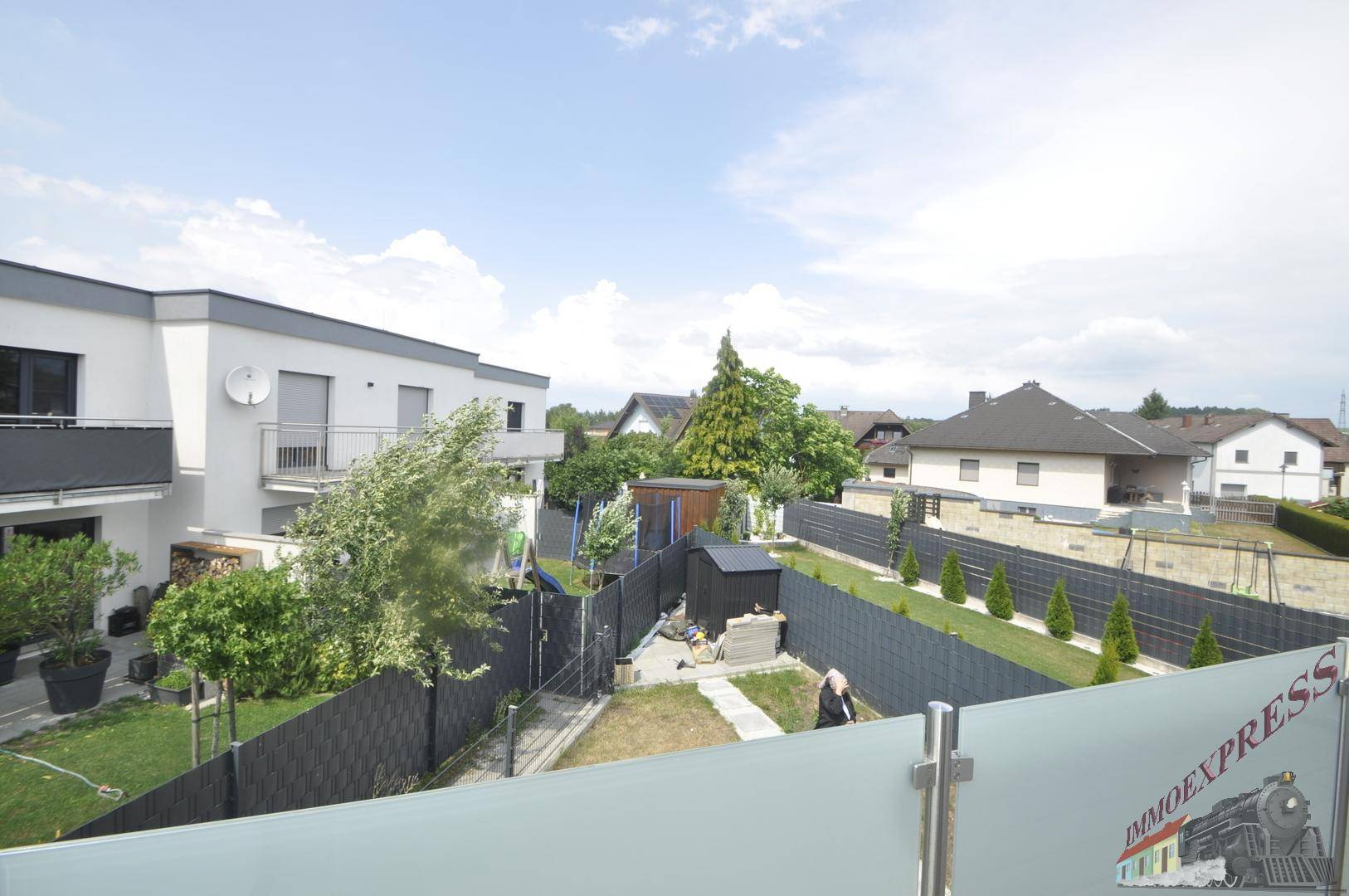 Blick vom Balkon auf den Garten und die umliegende Wohngegend.