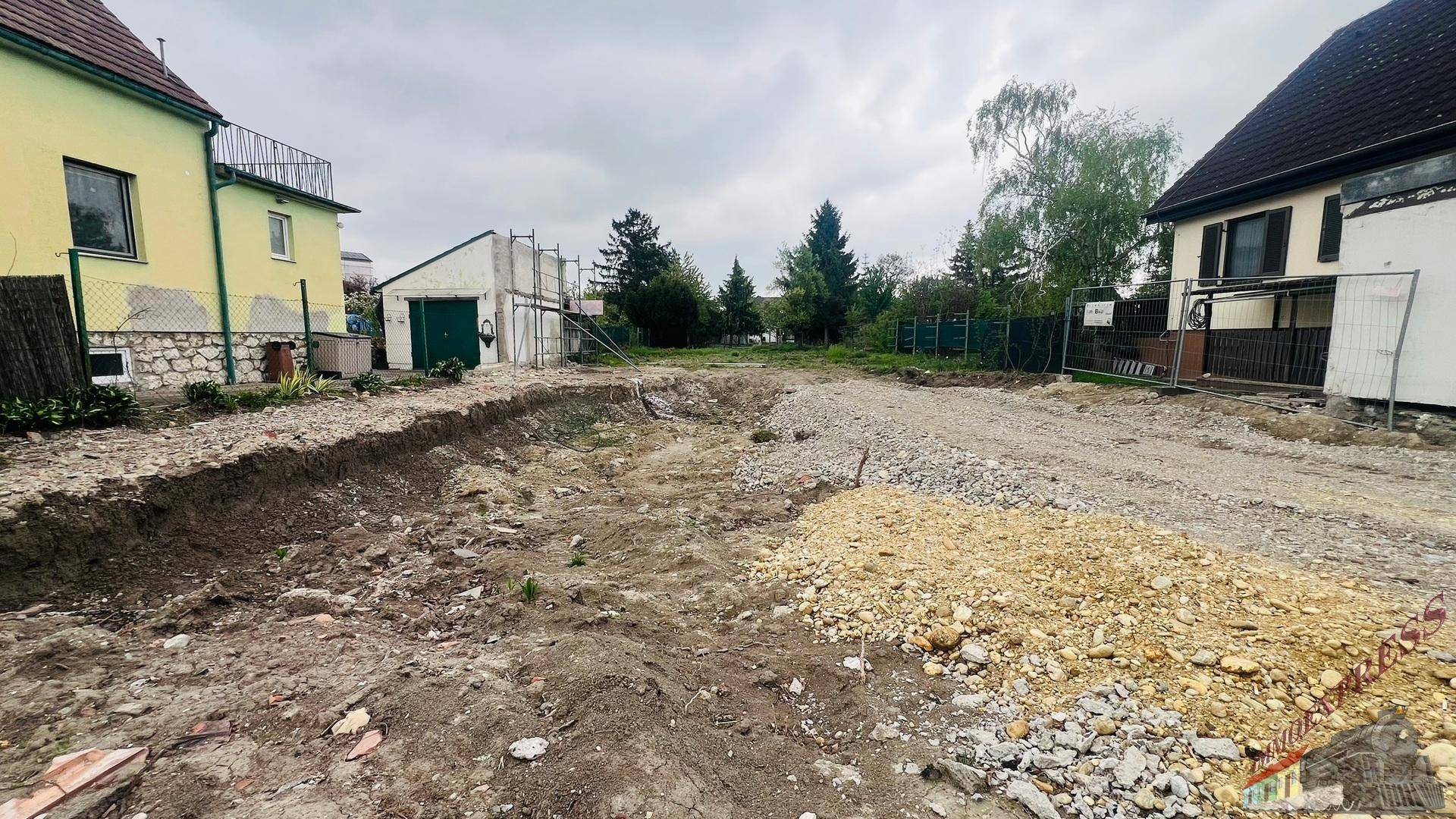 Baustelle mit Erdaushub und Schotter, bereit für den Neubau.