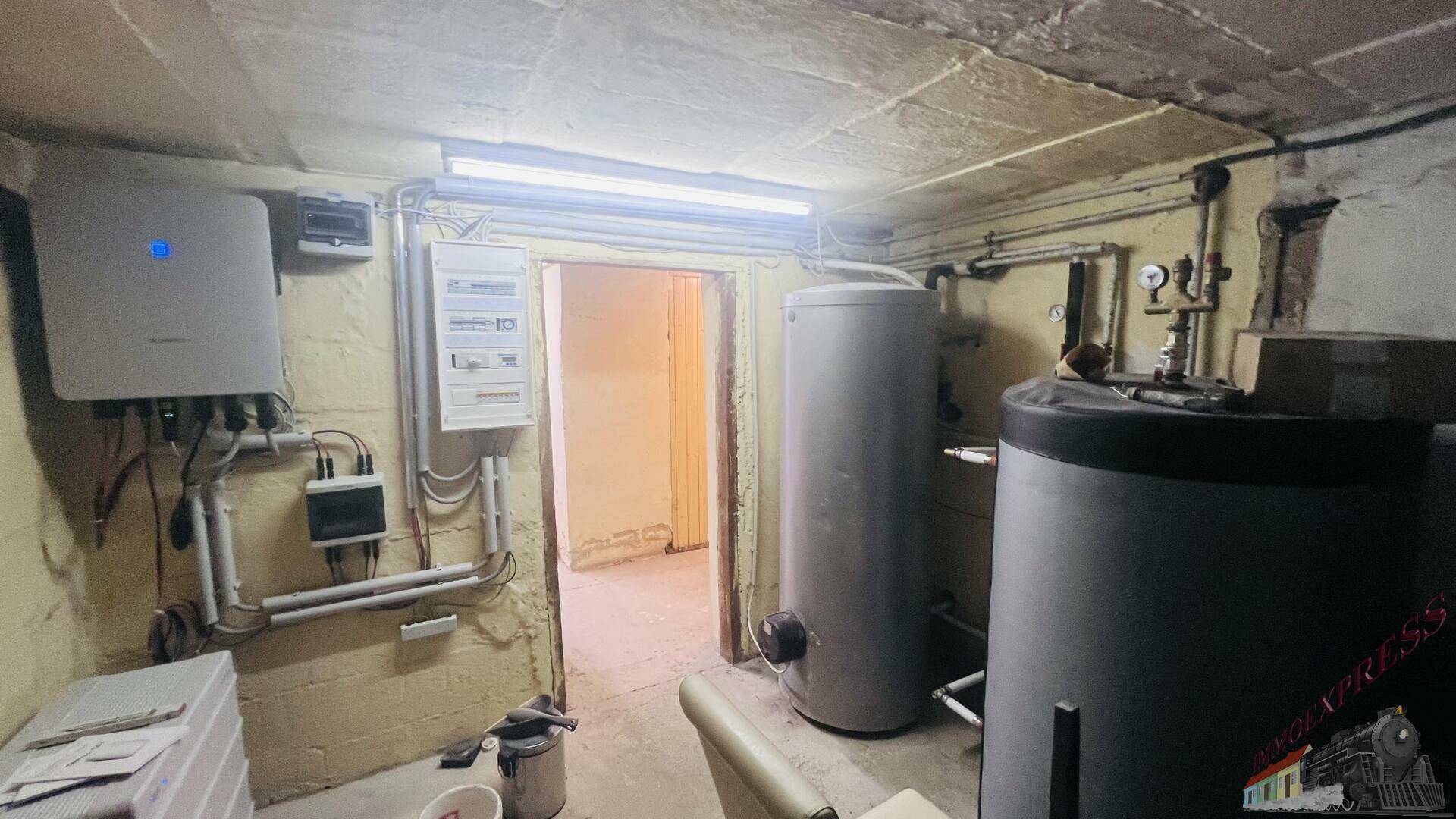 Kellerraum mit Heizungsanlage, Warmwasserspeichern und elektrischen Installationen.
