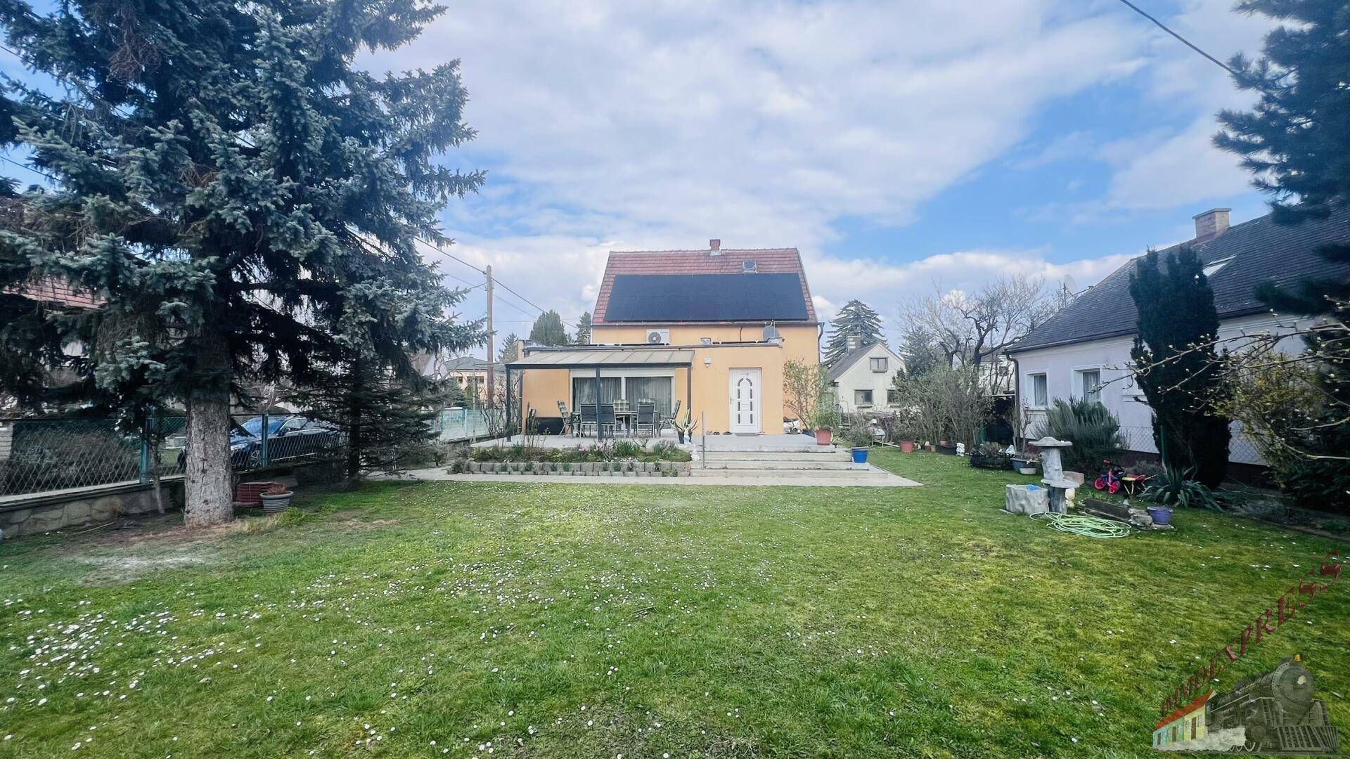 Großer, gepflegter Garten mit Rasenfläche und dem Wohnhaus mit Terrasse im Hintergrund.