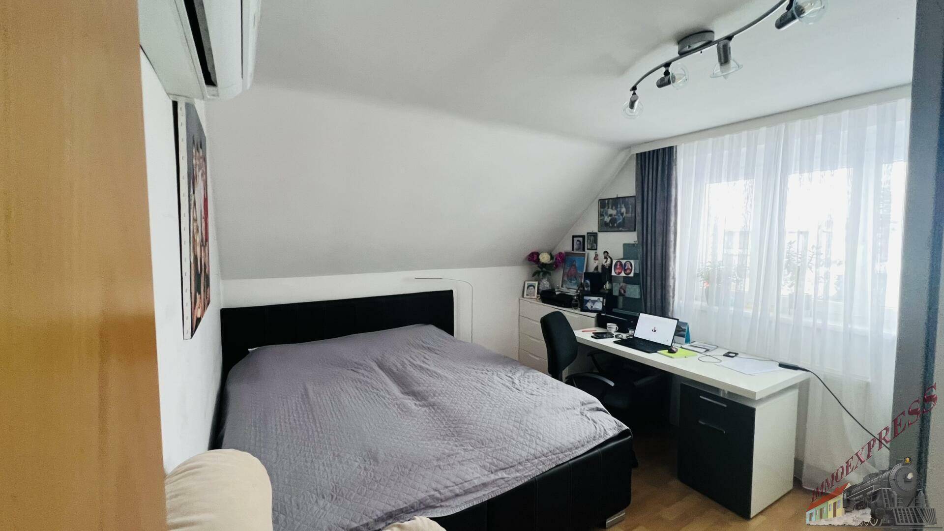 Gemütliches Schlafzimmer im Dachgeschoss mit Doppelbett, Schreibtisch und Klimaanlage.