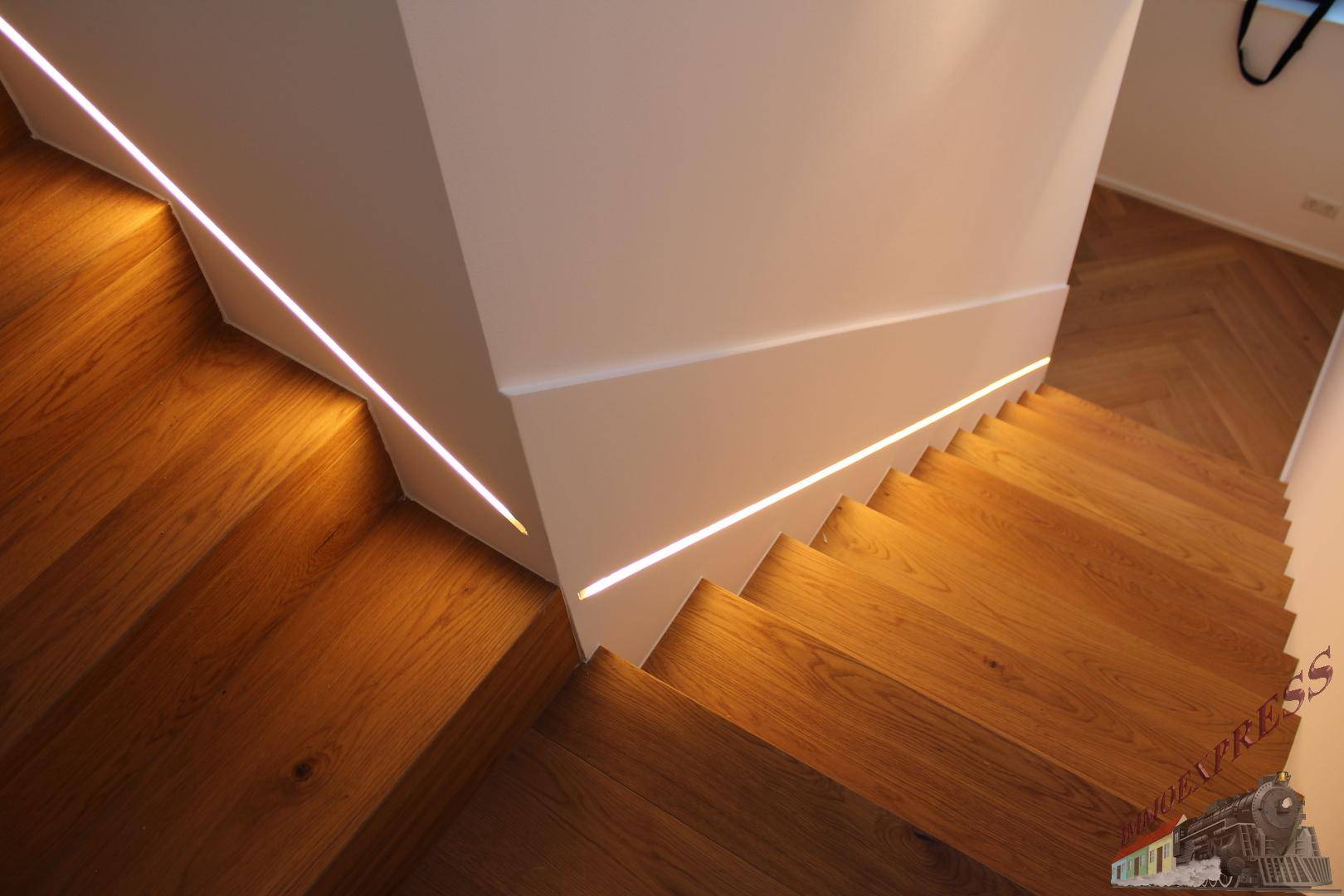 Moderne Holztreppe mit integrierter LED-Beleuchtung, die zum oberen Stockwerk führt.