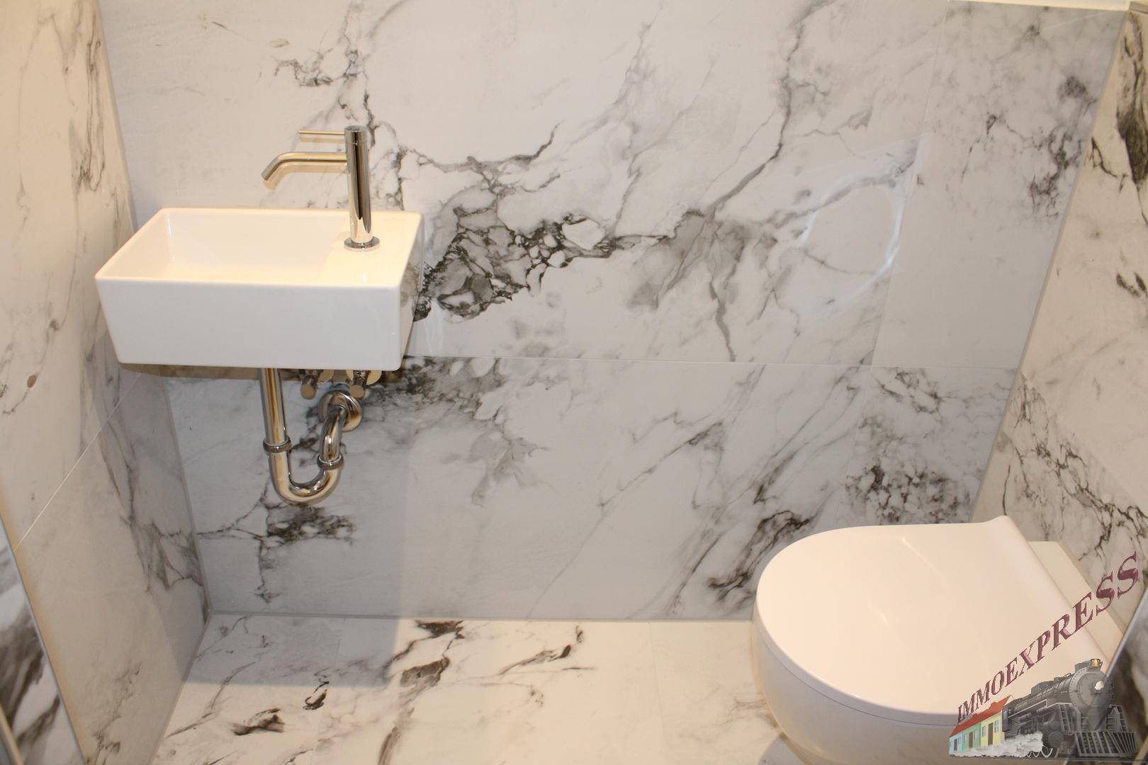 Elegantes Gäste-WC mit Marmorfliesen, wandhängendem WC und modernem Waschbecken.