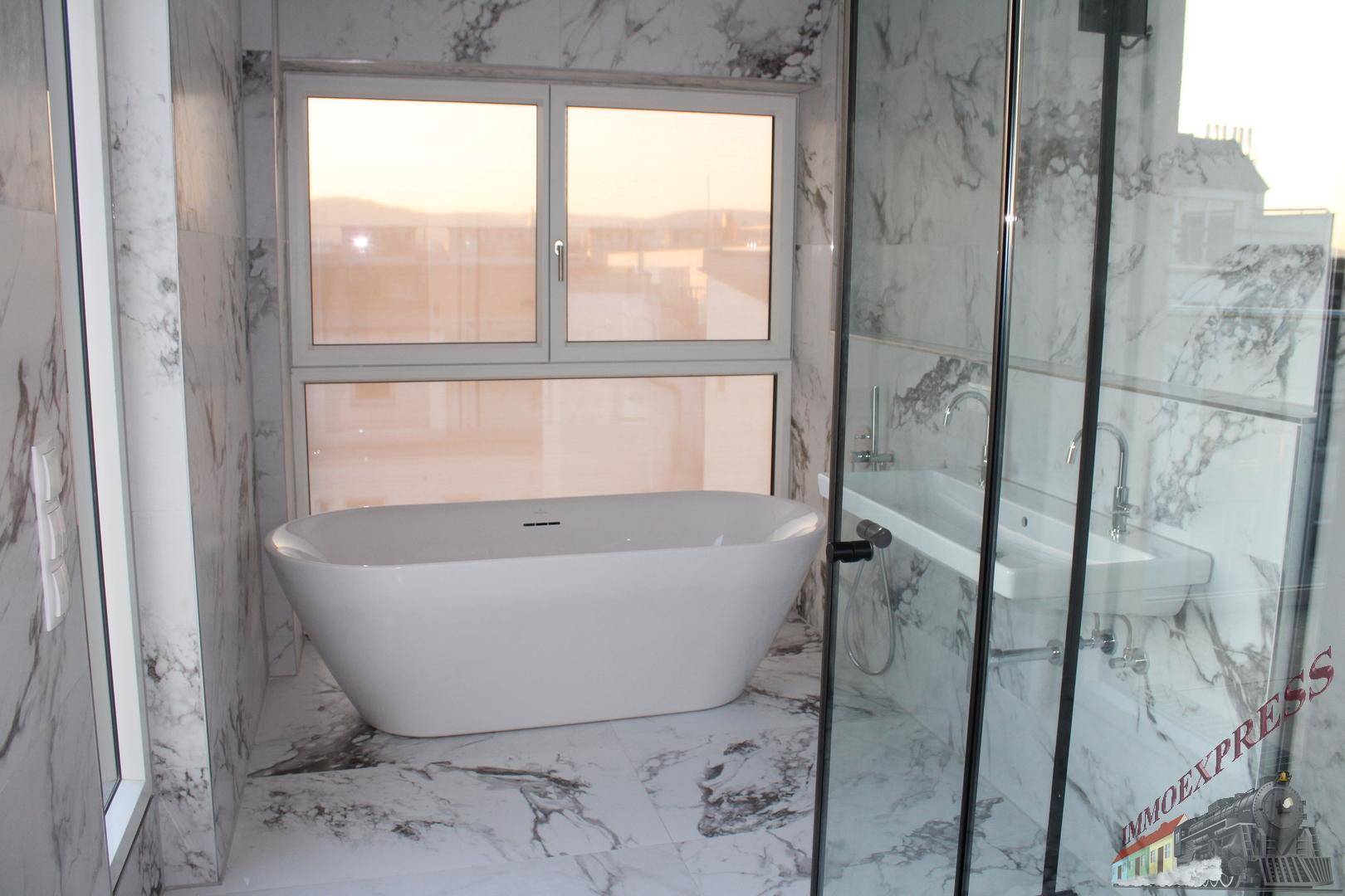 Luxuriöses Badezimmer mit freistehender Badewanne, Marmorfliesen und großem Fenster.