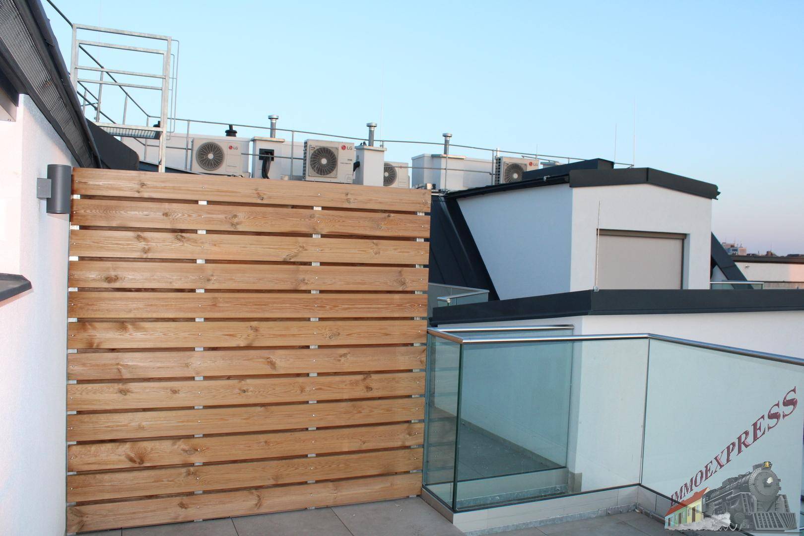Dachterrasse mit Holzverkleidung als Sichtschutz und Blick auf die umliegenden Gebäude.