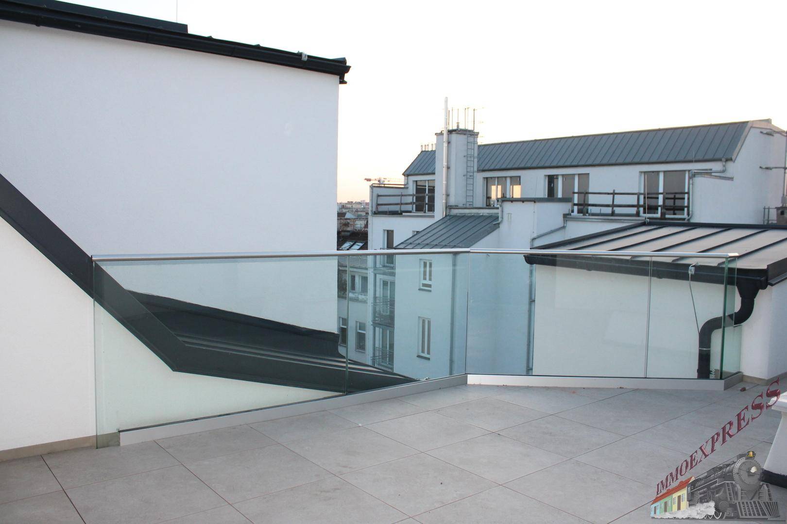 Weitläufige Dachterrasse mit Glasgeländer und Panoramablick über die Stadt.