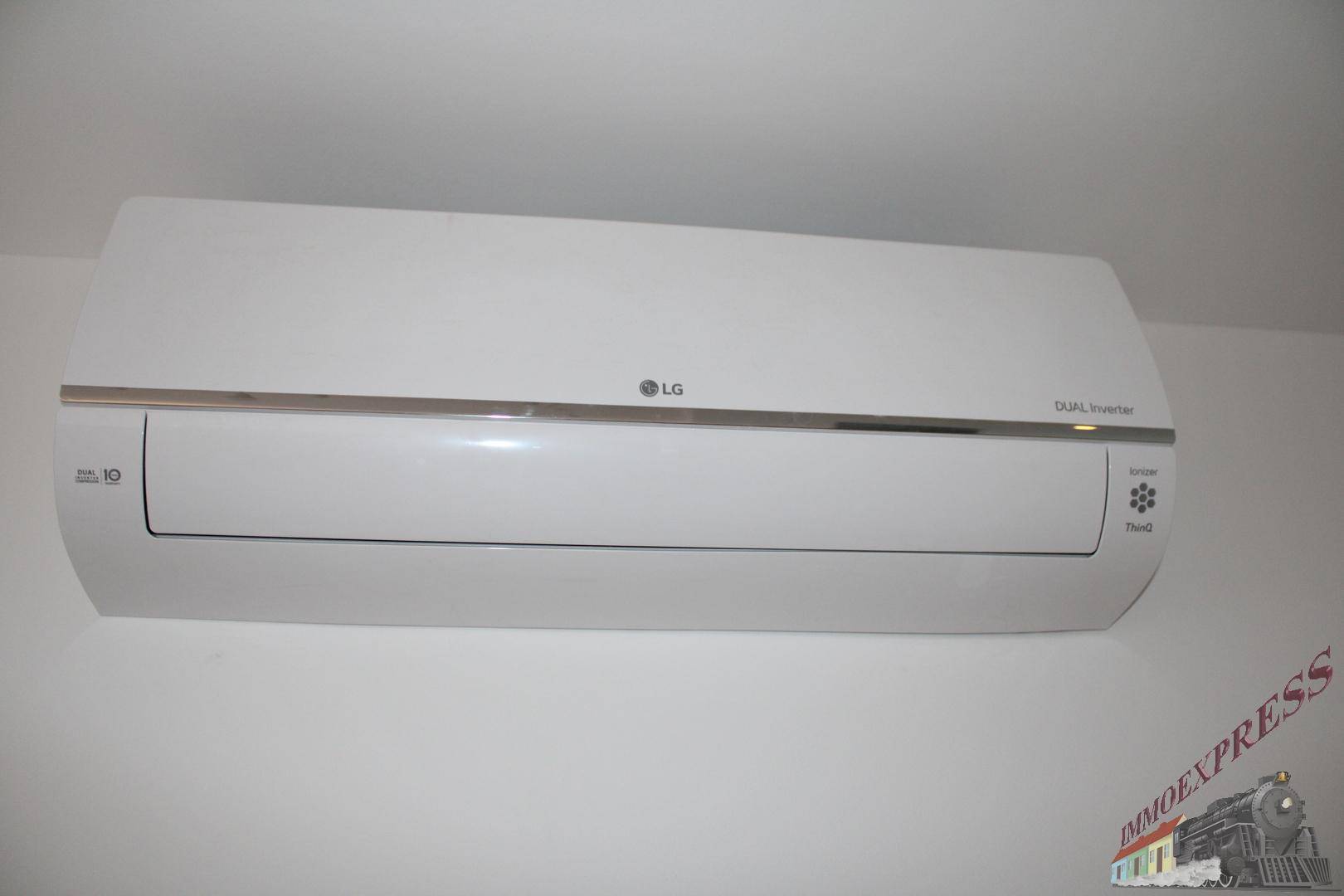 Eine moderne LG Dual Inverter Klimaanlage ist an der weißen Wand montiert.