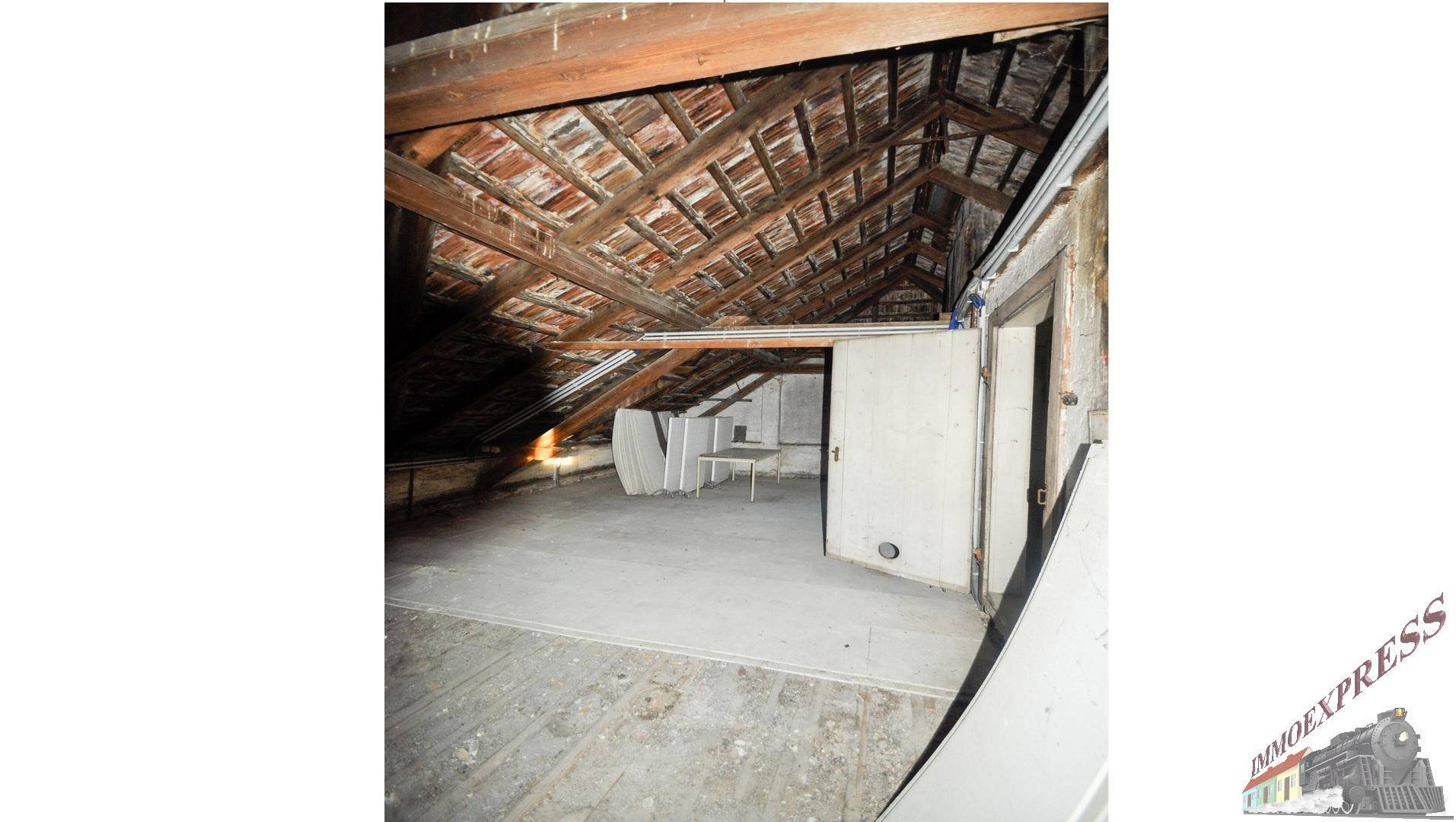 Unausgebauter Dachboden mit sichtbaren Holzbalken und Dachkonstruktion, bietet Ausbaupotenzial.