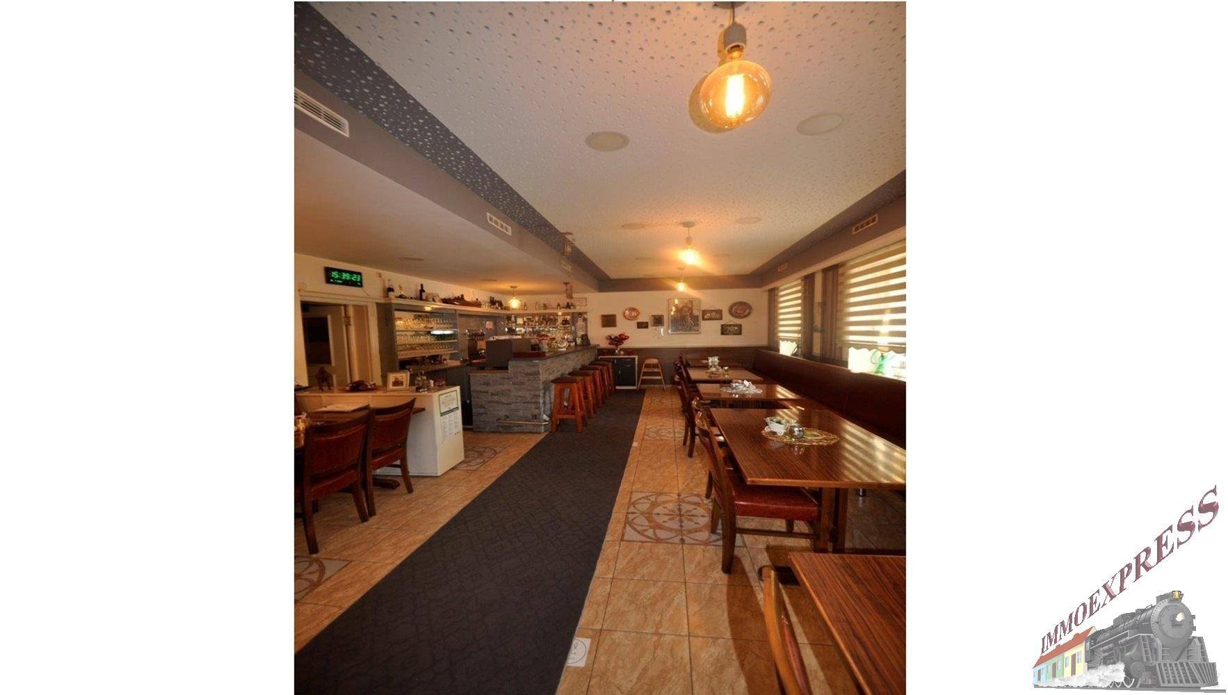 Geräumiger Restaurantbereich mit Holztischen, Stühlen und Blick zur Bar, einladend für Gäste.