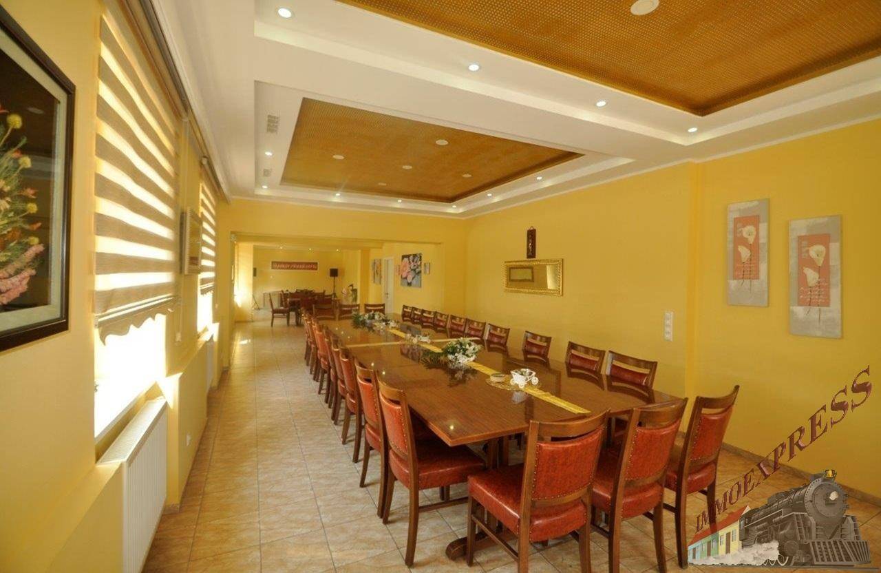 Langer Speisesaal mit festlich gedeckten Tischen und dekorativer Deckenbeleuchtung, ideal für Feiern.