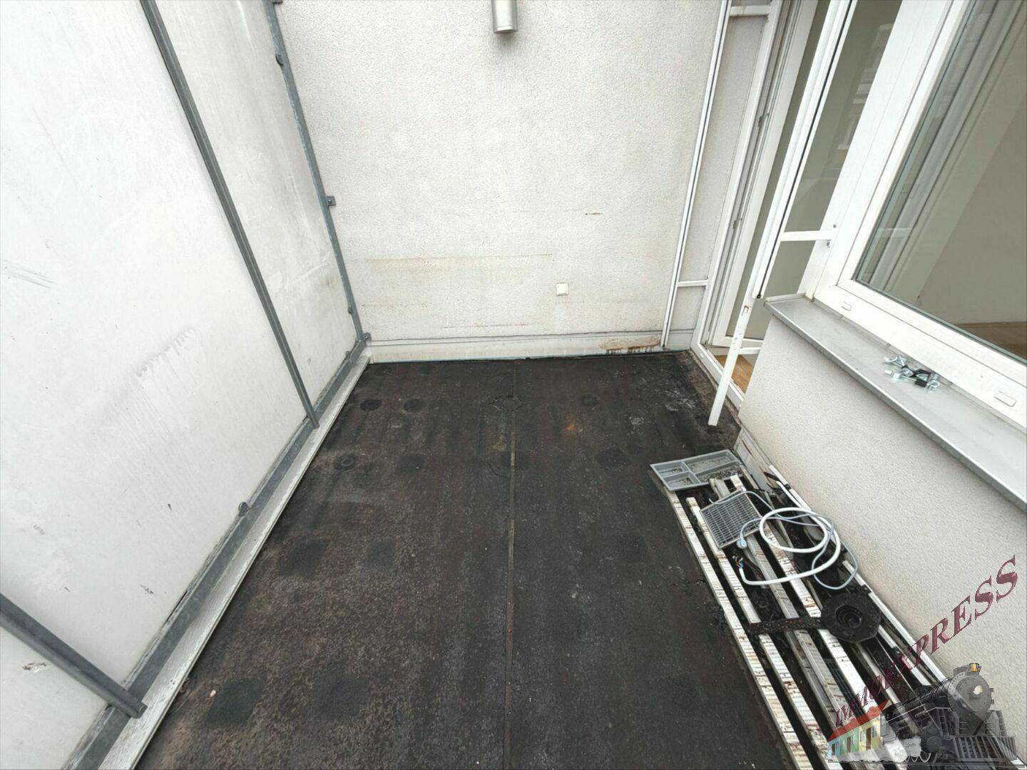 Schmaler Balkon mit robustem Bodenbelag und Zugangstür zum Innenbereich der Wohnung.