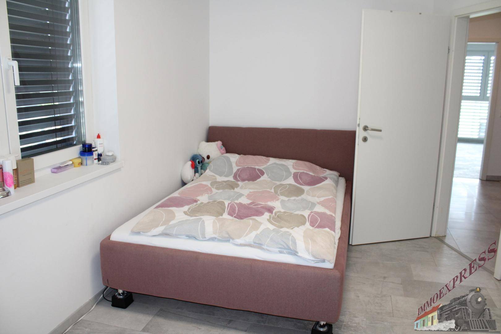 Kleines Schlafzimmer mit Einzelbett und Fenster, ideal als Kinder- oder Gästezimmer.