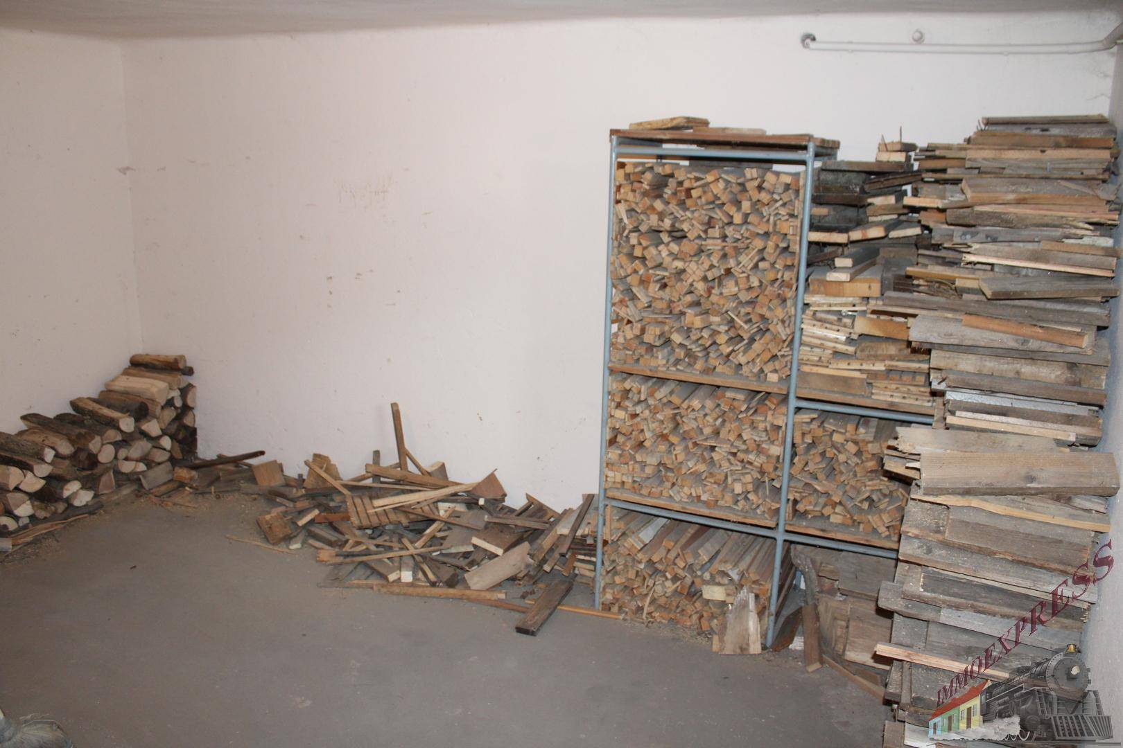 Lagerraum mit gestapeltem Brennholz und Holzresten für den Ofen.