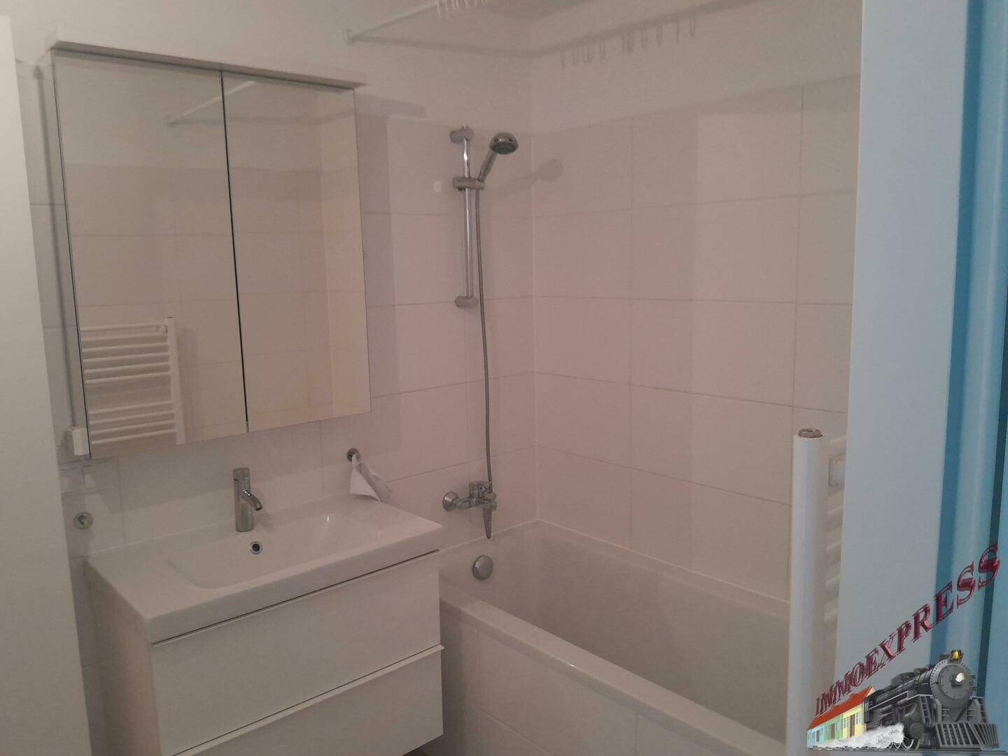 Helles Badezimmer mit Badewanne, Waschbecken und Spiegelschrank.