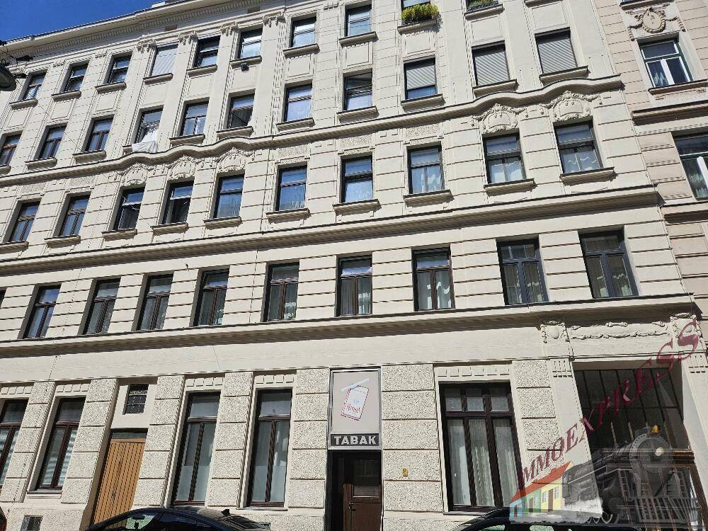 Klassische Altbaufassade mit vielen Fenstern und dekorativen Elementen in der Stadt.