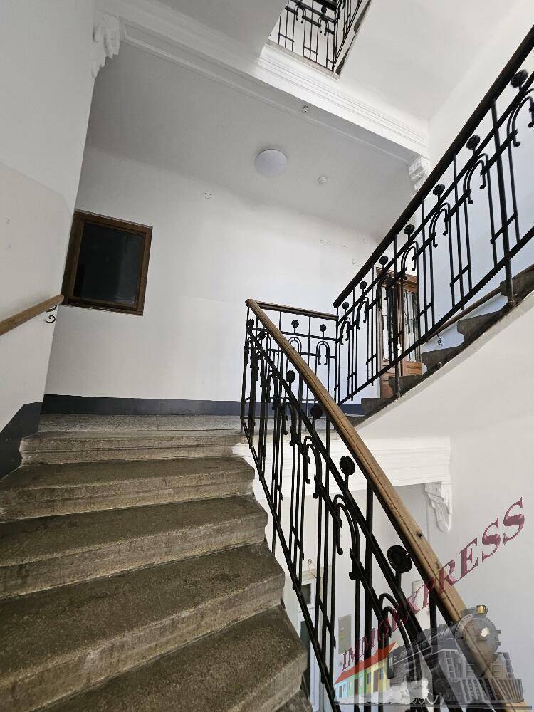 Historisches Treppenhaus mit Steinstufen und schmiedeeisernem Geländer in einem Altbau.