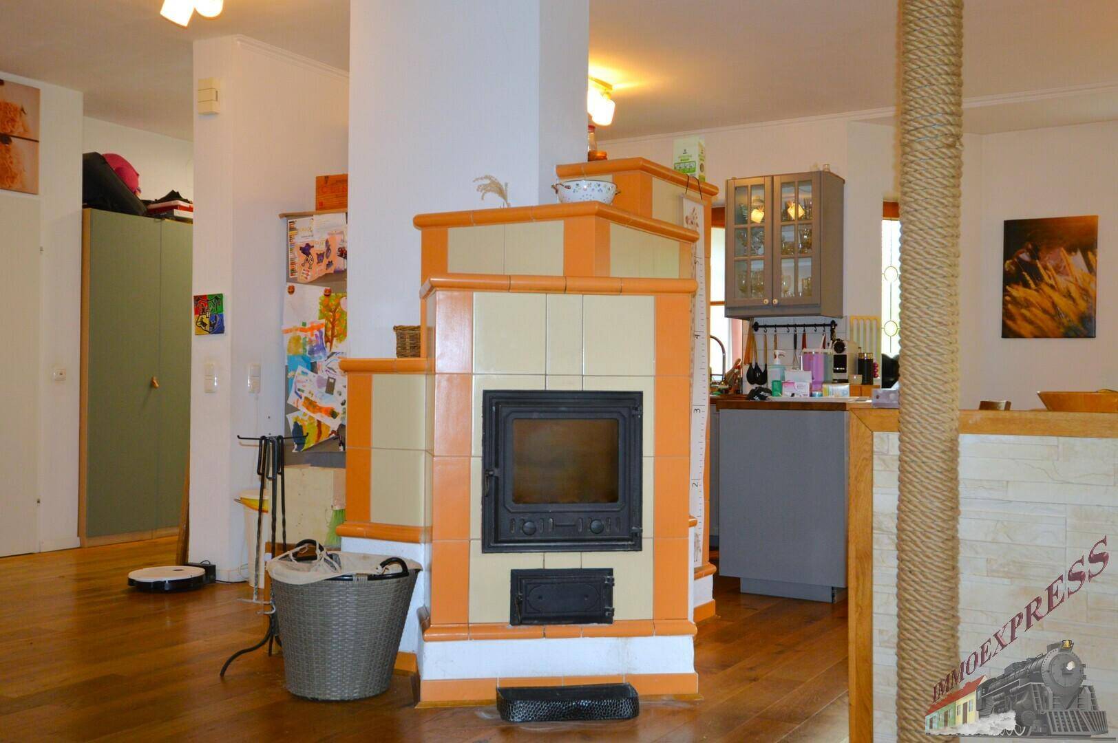 Detailansicht des traditionellen Kachelofens, der den Wohnbereich mit der Küche harmonisch verbindet.
