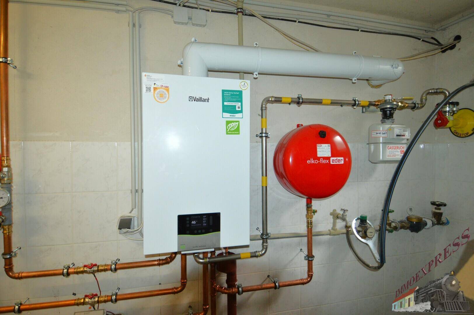Heizungsraum mit moderner Gastherme und Warmwasserspeicher.
