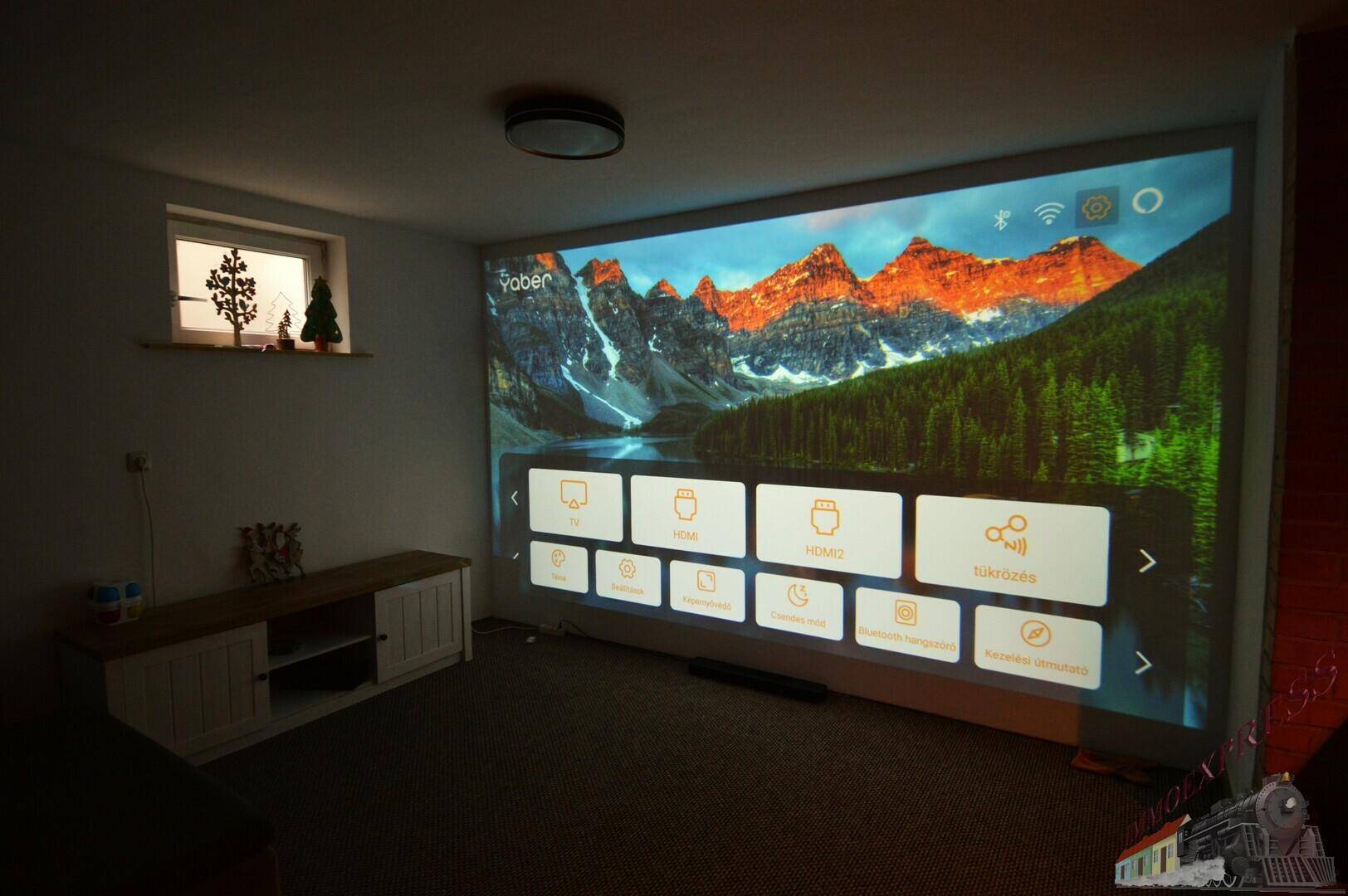Dunkler Medienraum mit großem Projektorbildschirm und gemütlichem Sofa.