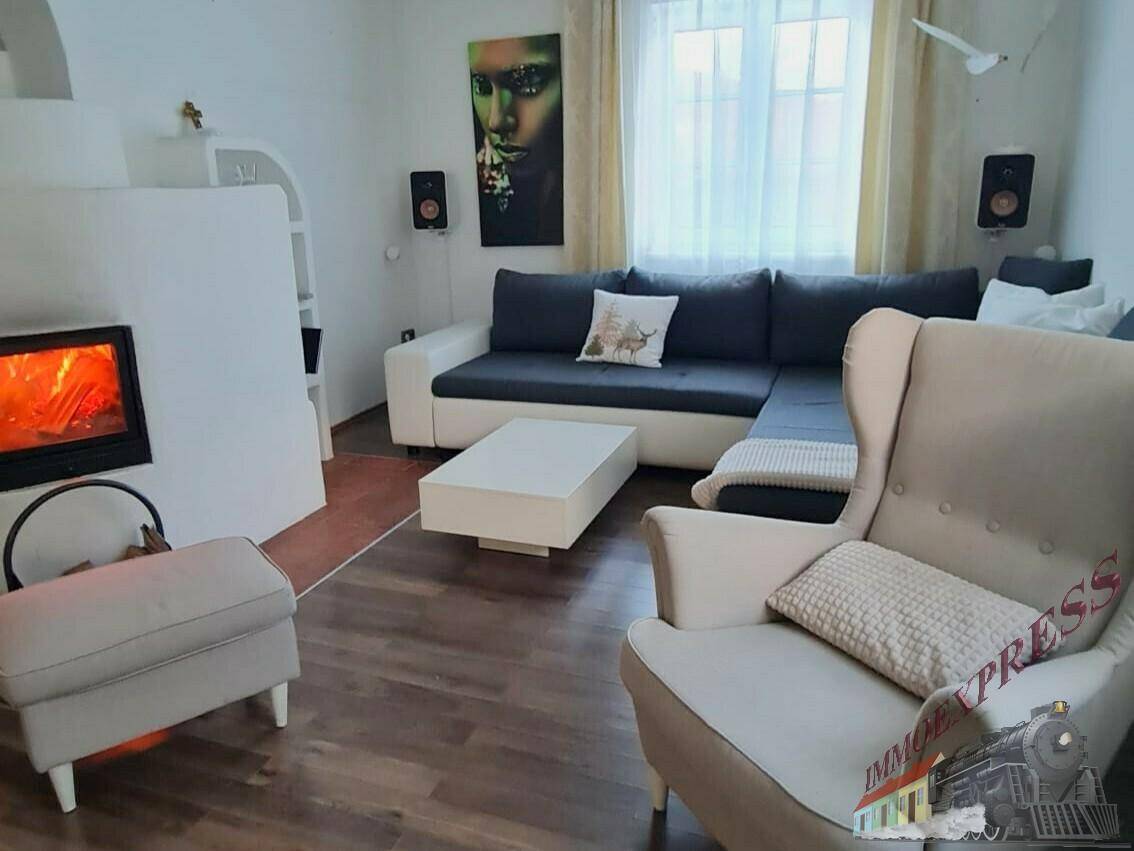 Gemütliches Wohnzimmer mit Kamin, Ecksofa und hellem Parkettboden für entspannte Abende.