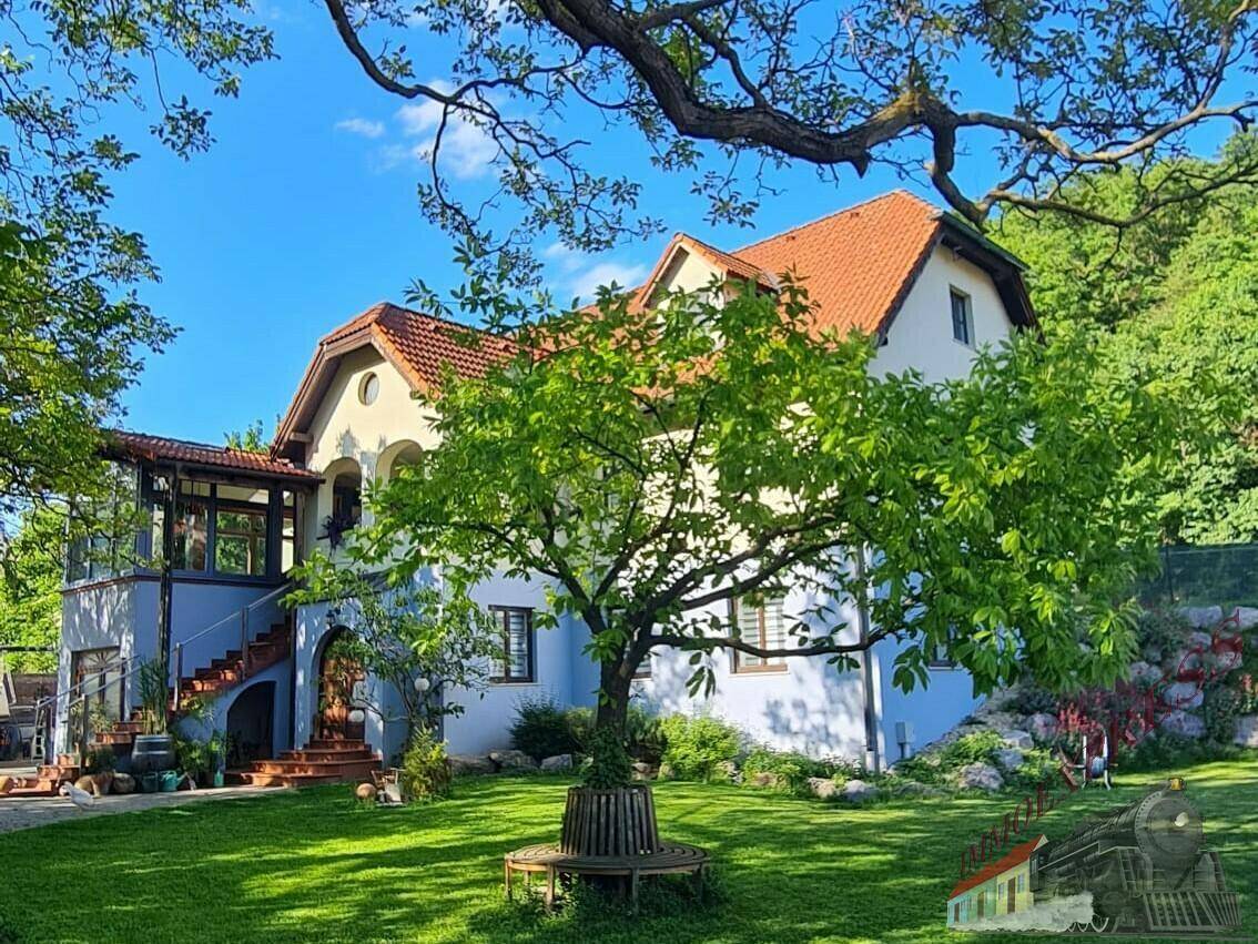 Charmantes Haus mit großem Garten, altem Baumbestand und traditioneller Architektur.