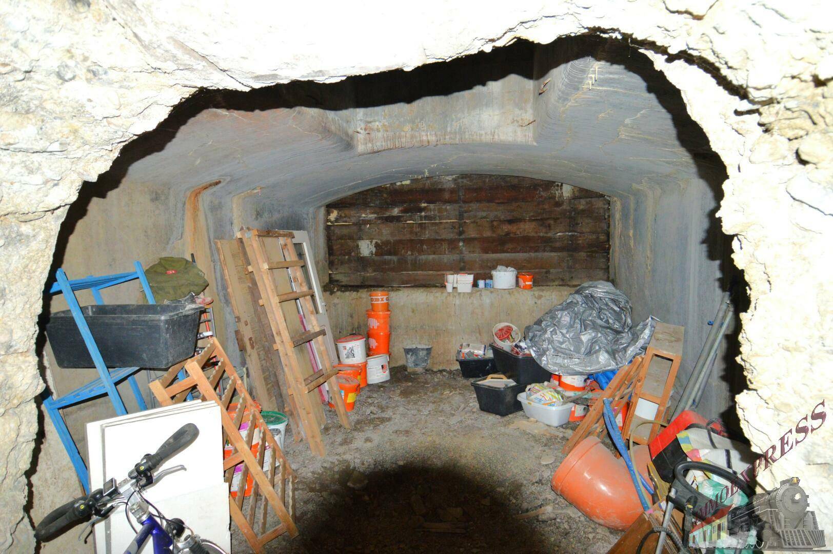 Rustikaler Kellerraum mit gewölbter Decke und unebenen Wänden, genutzt als Lagerfläche.