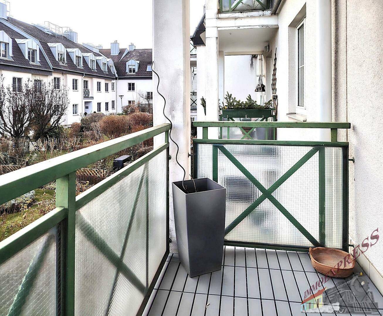 Balkon mit Pflanzkübel und Blick auf die umliegenden Wohngebäude.