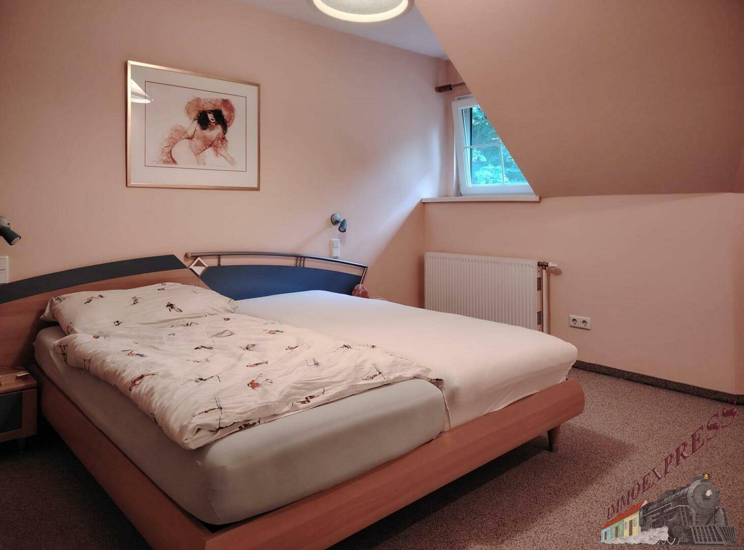 Gemütliches Schlafzimmer im Dachgeschoss mit Einzelbetten, Teppichboden und schrägen Wänden.