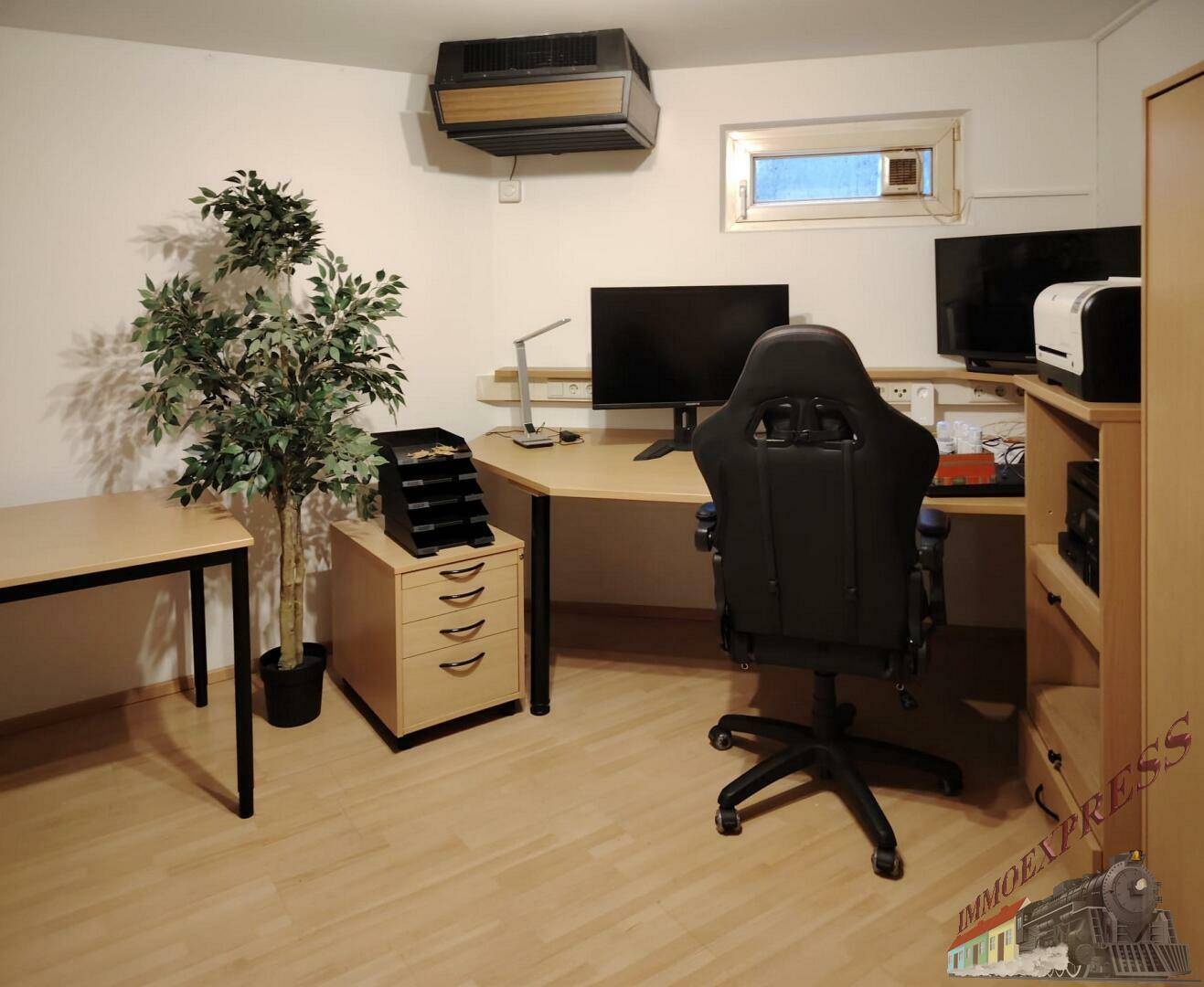 Funktionales Büro mit Schreibtisch, Computerarbeitsplatz und Laminatboden, ideal für Home-Office.