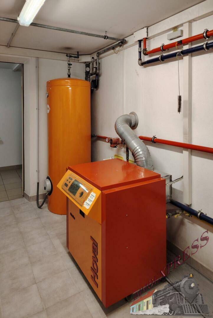 Technikraum mit Heizungsanlage und Warmwasserspeicher, gut zugänglich für Wartungsarbeiten.