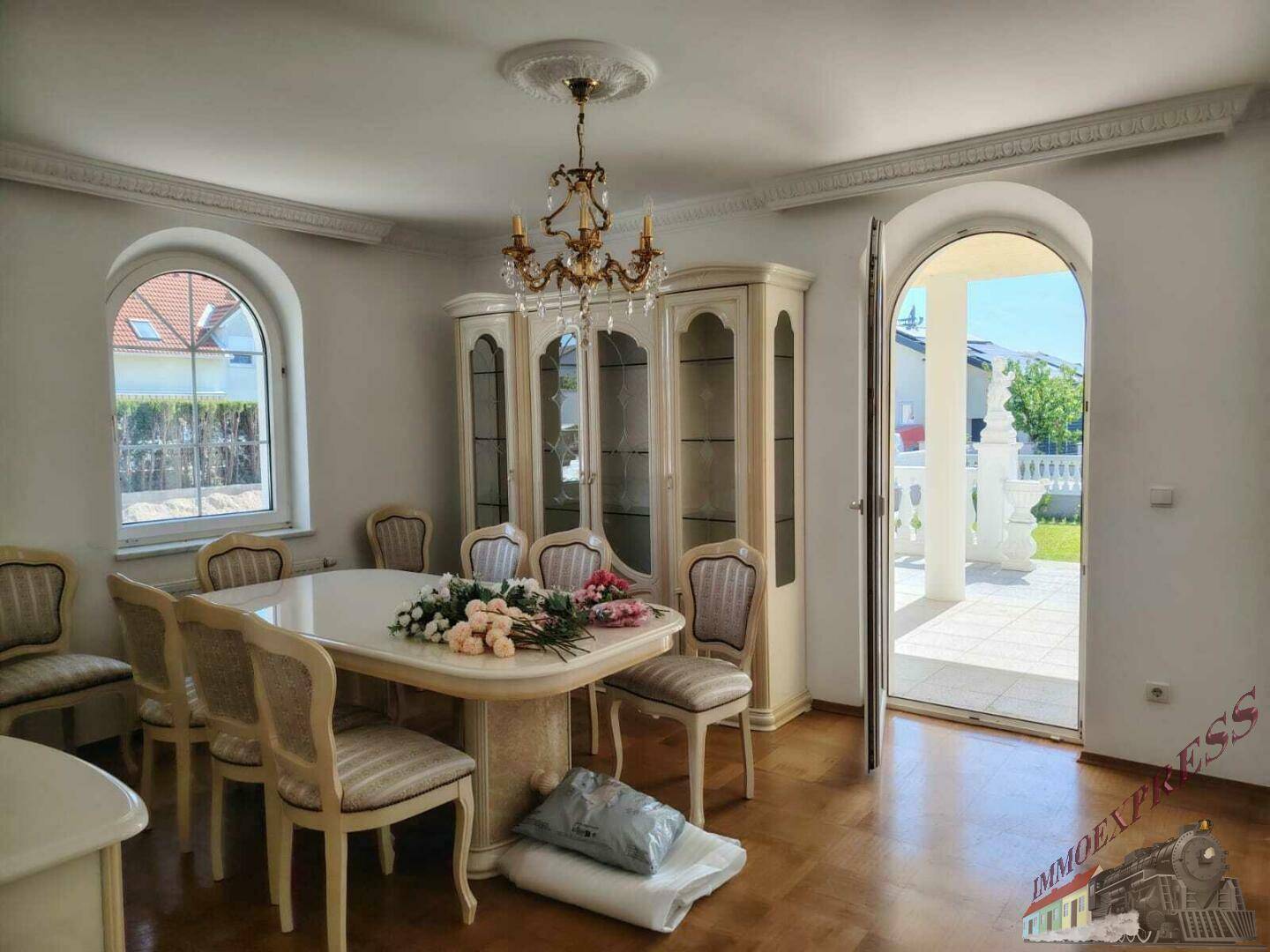Klassisches Esszimmer mit eleganten Möbeln, Kronleuchter und direktem Zugang zur Terrasse.