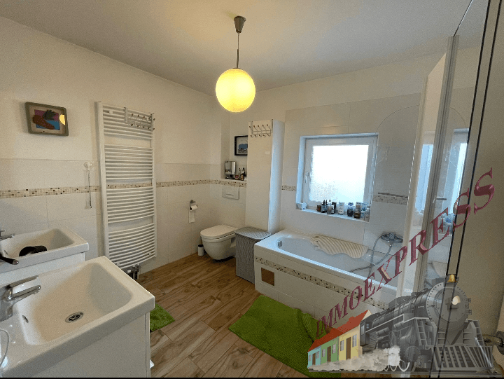 Geräumiges Badezimmer mit Badewanne, Dusche, Doppelwaschbecken und Fenster.