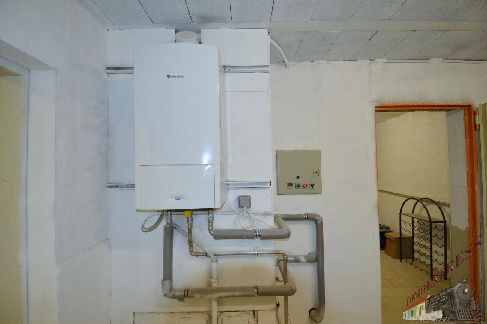 Hauswirtschaftsraum mit einer modernen Wandheizungsanlage und sichtbaren Rohrleitungen.