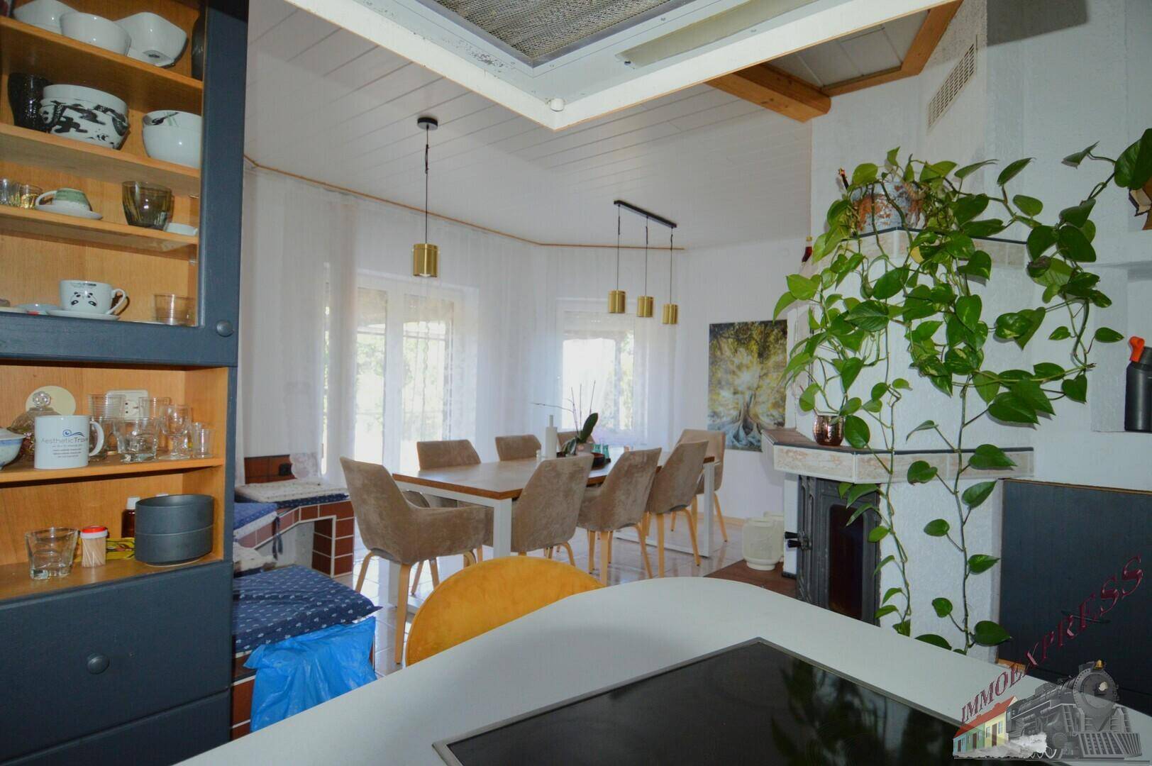 Offene Küche mit Essbereich, Kamin und Blick auf den Garten.
