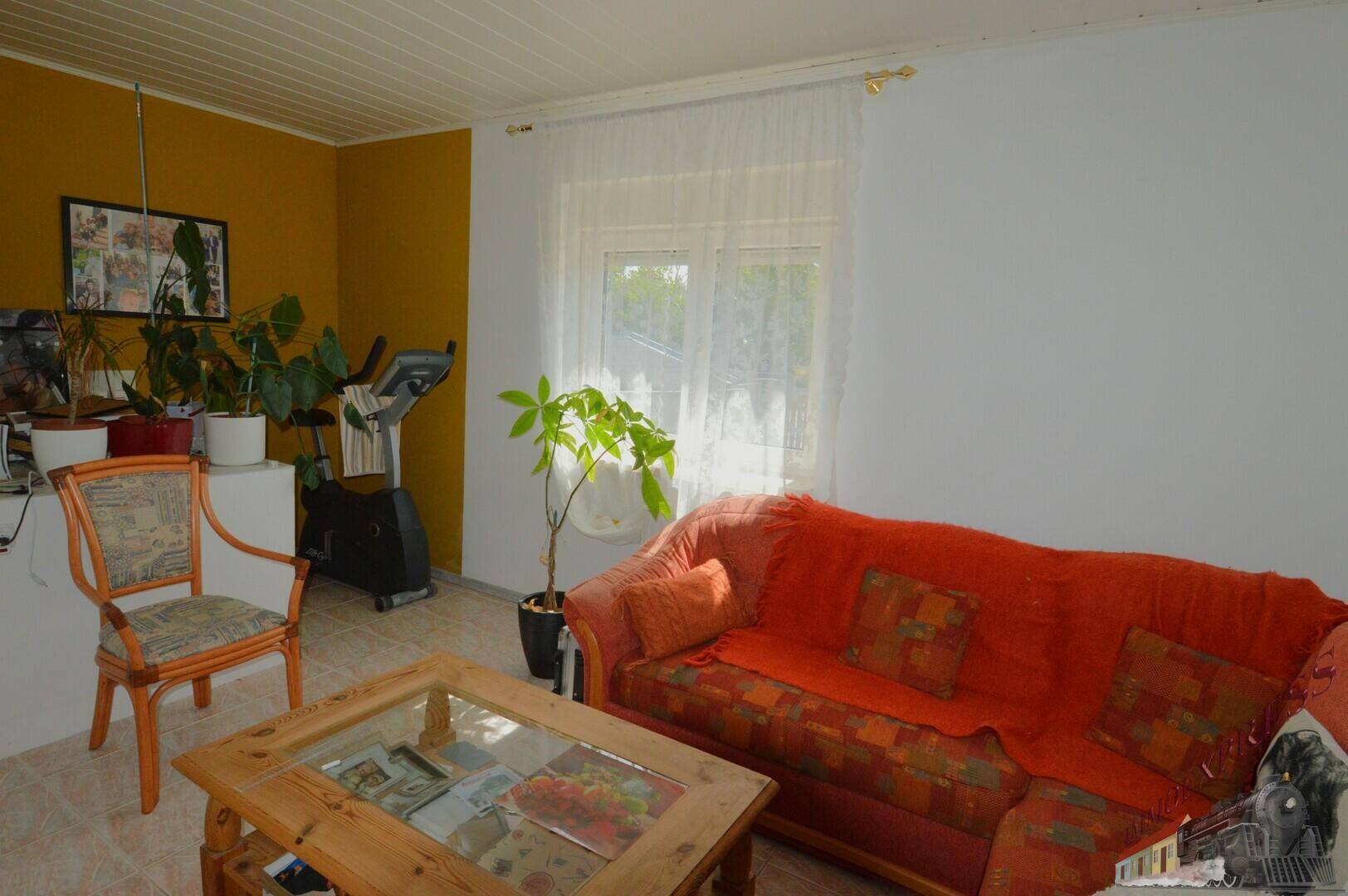 Gemütlicher Raum mit Sofa, Couchtisch und Fitnessgerät.