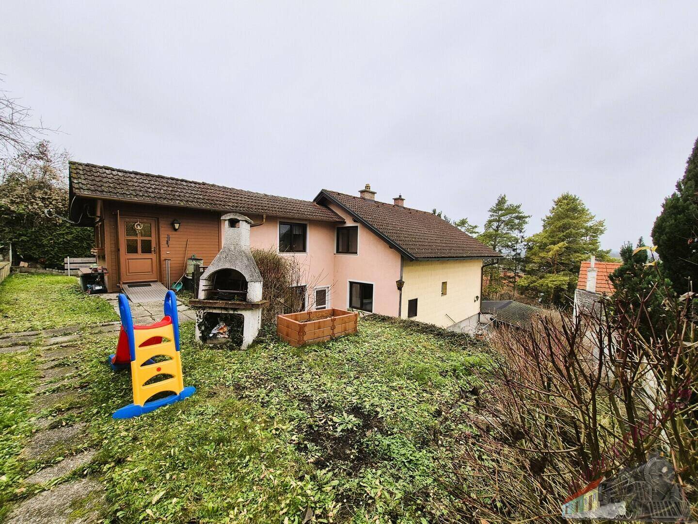 Hinterhof mit Grillplatz, Kinderspielgerät und Blick auf das Haus.