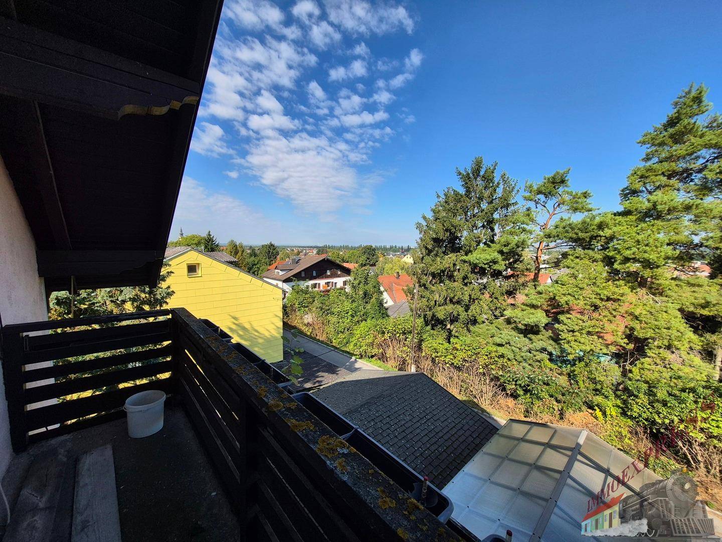 Balkon mit Holzgeländer und weitem Blick über die umliegende Nachbarschaft.