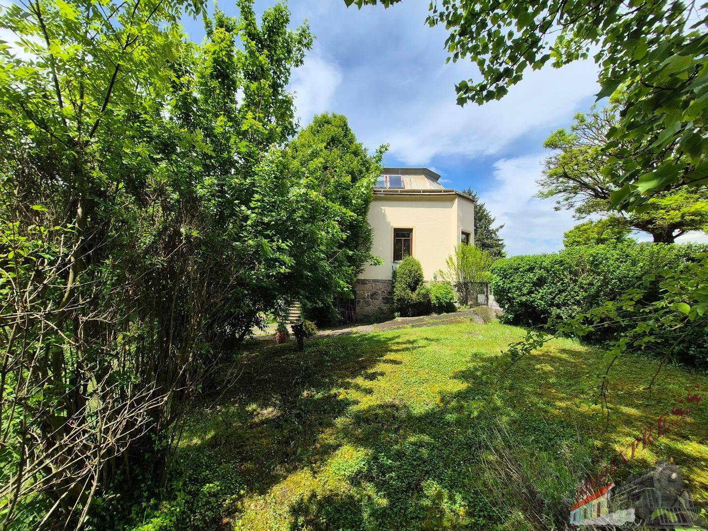 Großer Gartenbereich mit altem Baumbestand und Blick auf die Rückseite des Hauses.