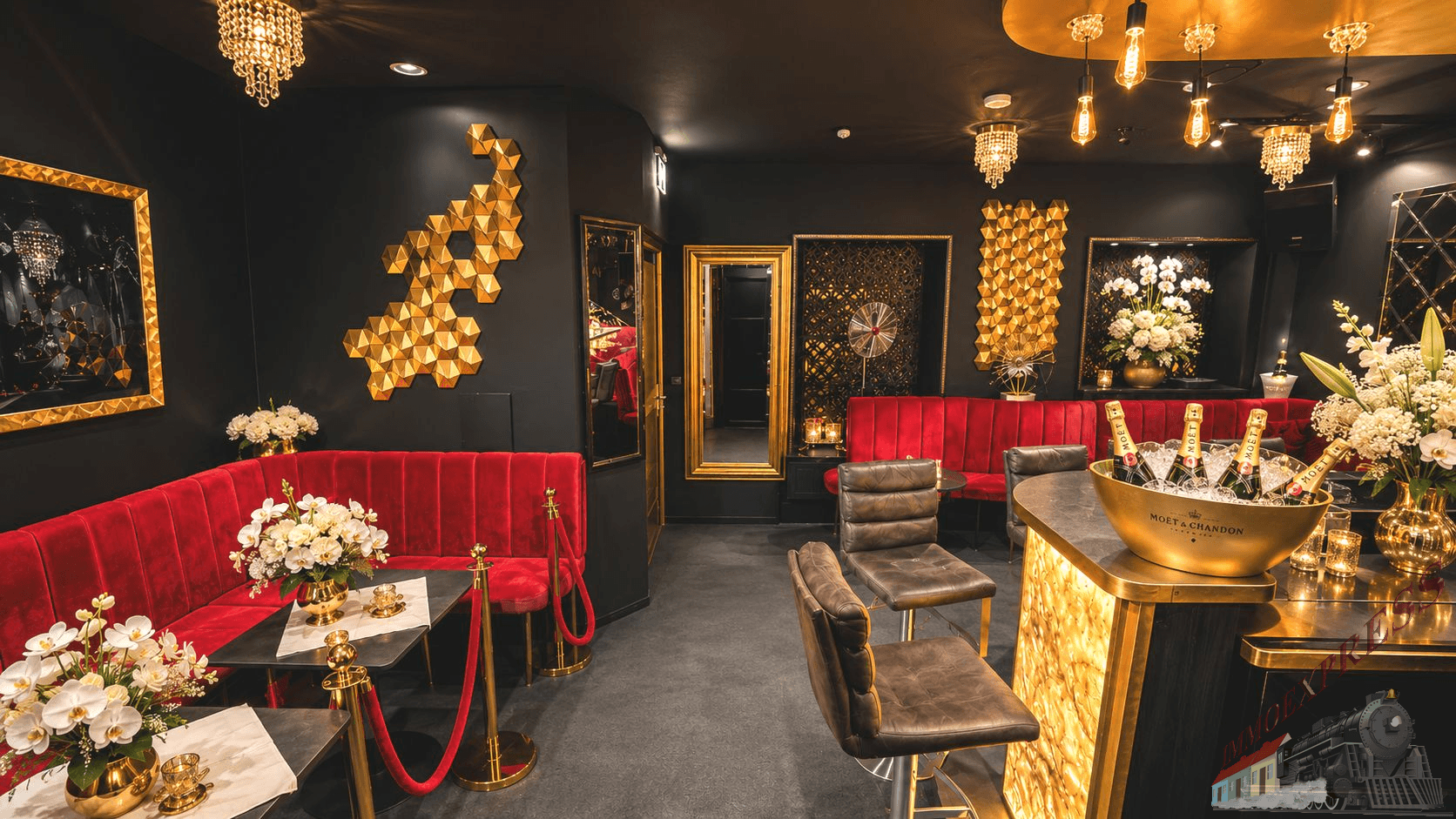Elegante Bar mit roten Sitzgelegenheiten, goldenen Dekorationen und dunklen Wänden für eine exklusive Atmosphäre.
