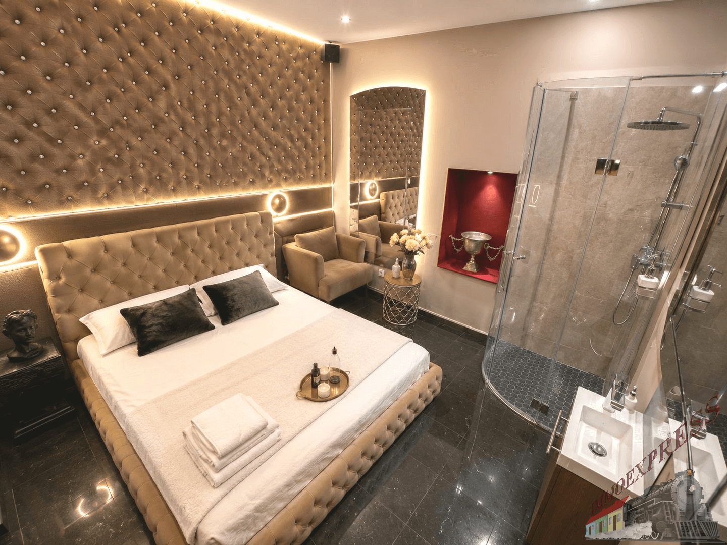 Modernes Schlafzimmer mit großem Polsterbett, offener Dusche und stilvoller Beleuchtung.