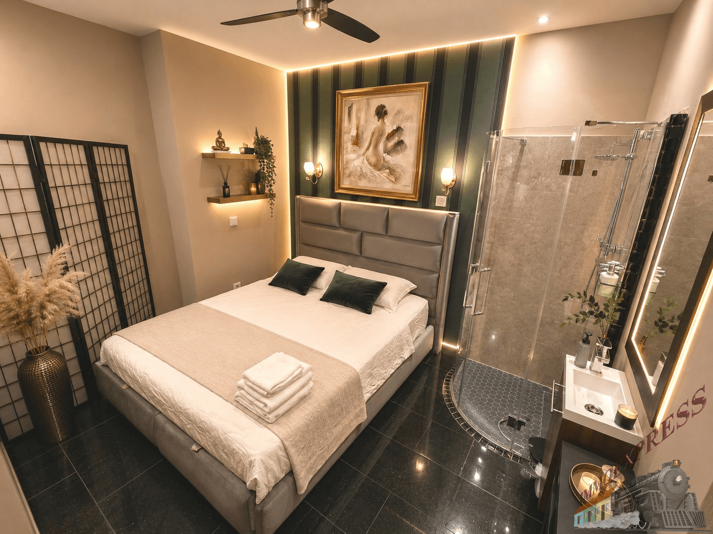 Elegantes Schlafzimmer mit grauem Polsterbett, gestreifter Akzentwand und offener Duschkabine.