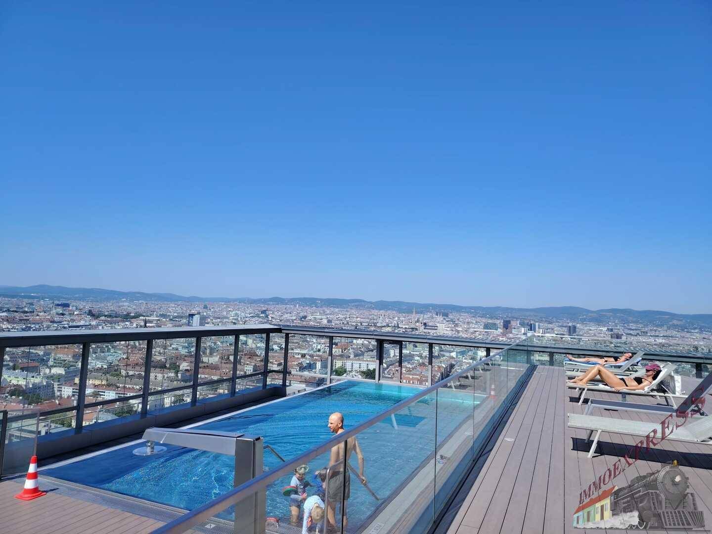 Dachterrasse mit Infinity-Pool und Sonnenliegen bietet einen atemberaubenden Panoramablick über die Stadt.