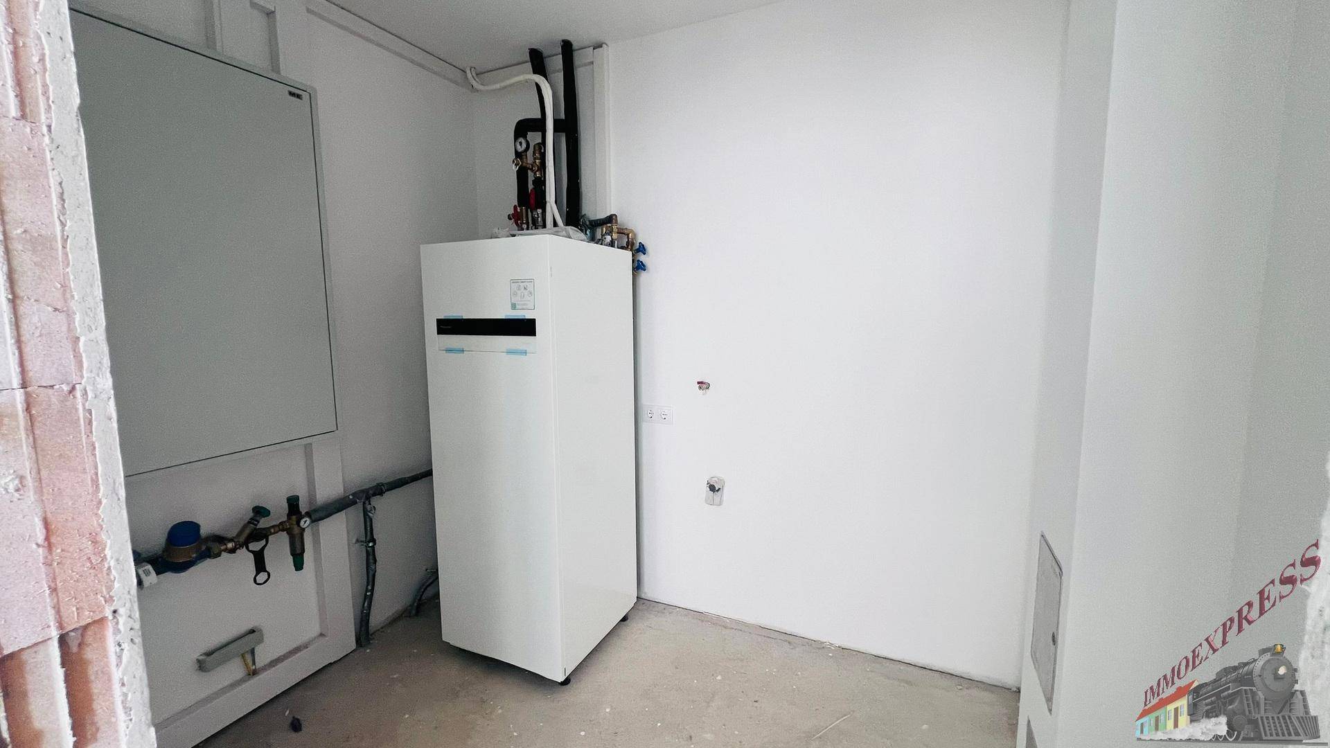 Hauswirtschaftsraum mit moderner Wärmepumpe und vorbereiteten Anschlüssen für die Haustechnik.