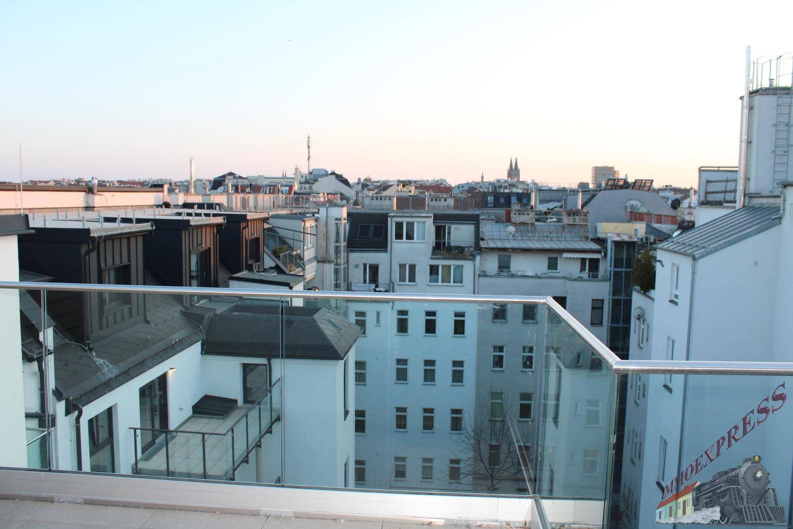 Weitläufiger Stadtblick von der Dachterrasse mit Glasgeländer und Blick auf die Skyline.