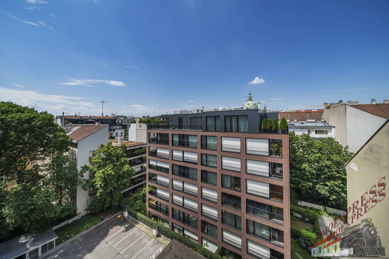 Panoramablick auf ein modernes Wohngebäude mit umliegender Stadtlandschaft und Grünflächen.