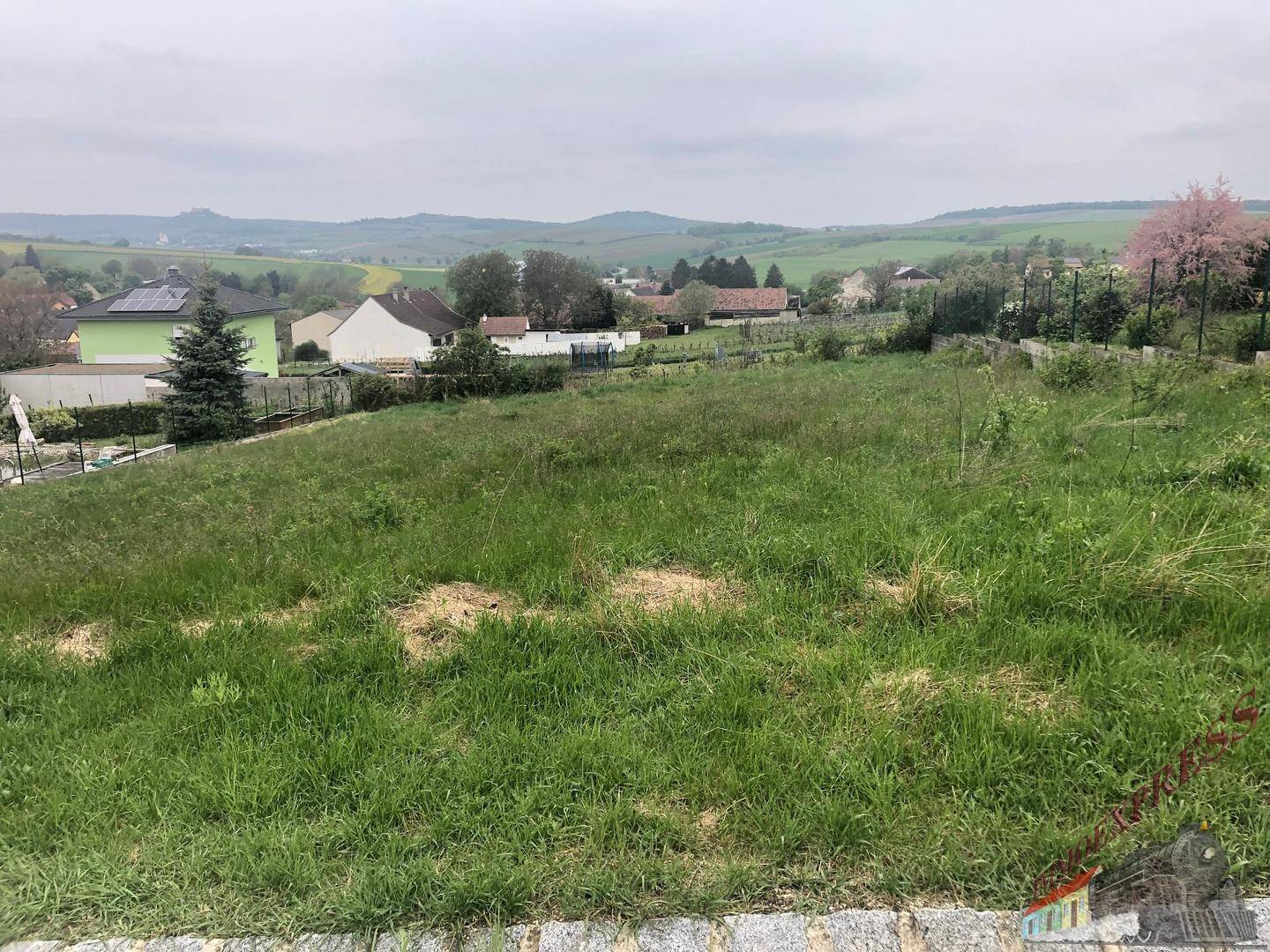 Großes, grünes Grundstück mit Blick auf die umliegende Landschaft und eine entfernte Burg.