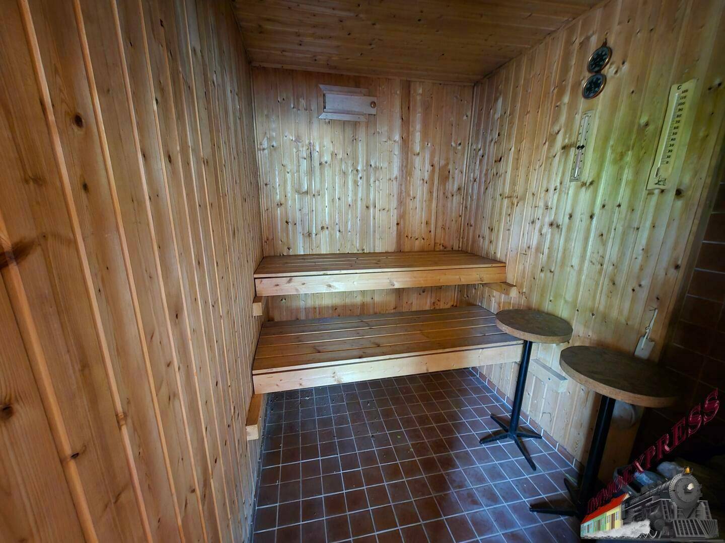 Helle Holzsauna mit zwei Liegeebenen und rustikalen Holzwänden für entspannende Momente.