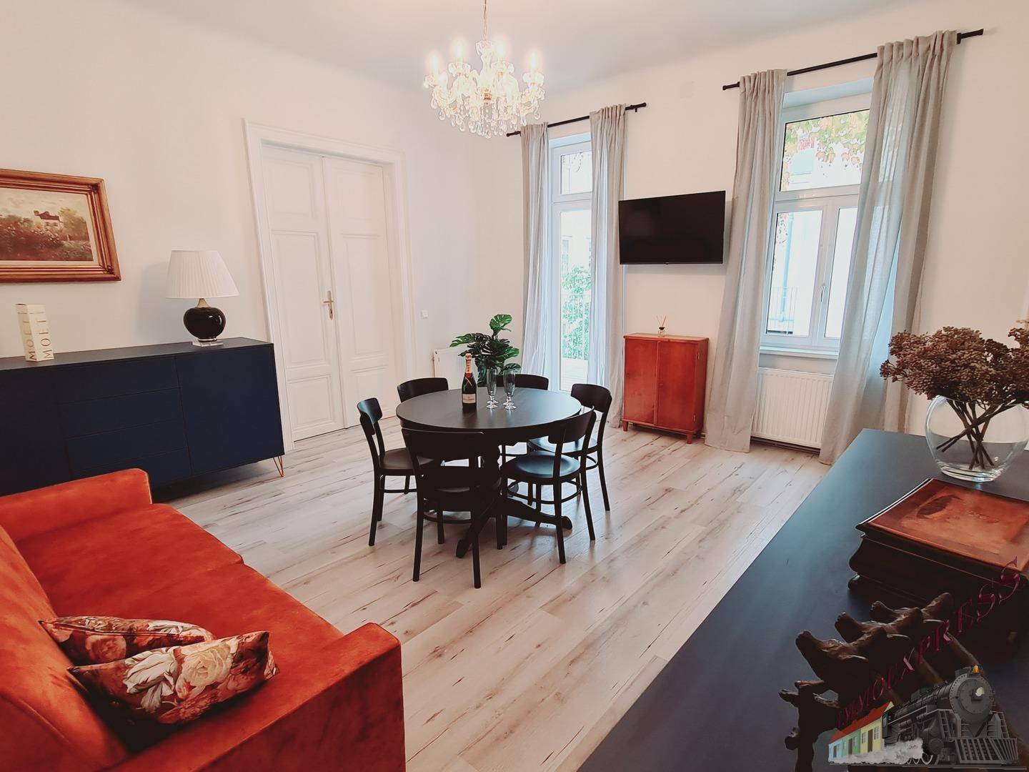 Heller Wohn-Essbereich mit modernem Esstisch, bequemer Couch und stilvoller Beleuchtung.