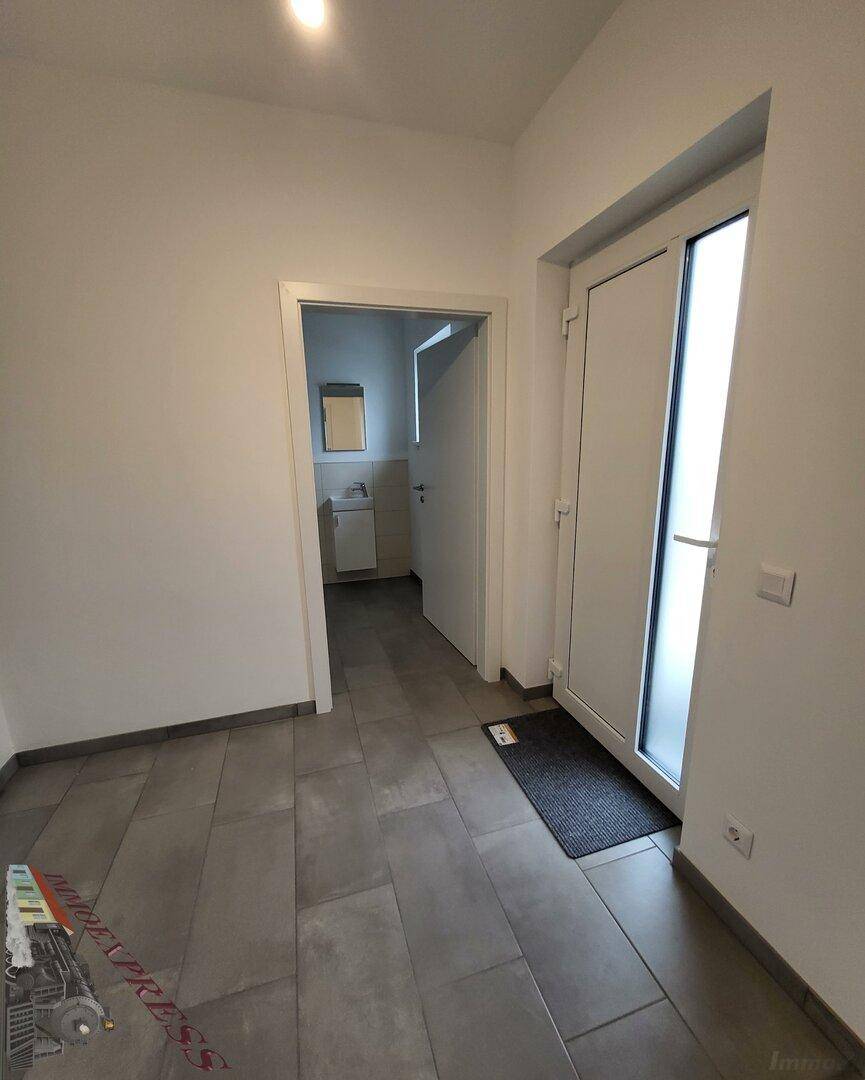 Heller Eingangsbereich mit Fliesenboden und Zugang zu einem Gäste-WC.