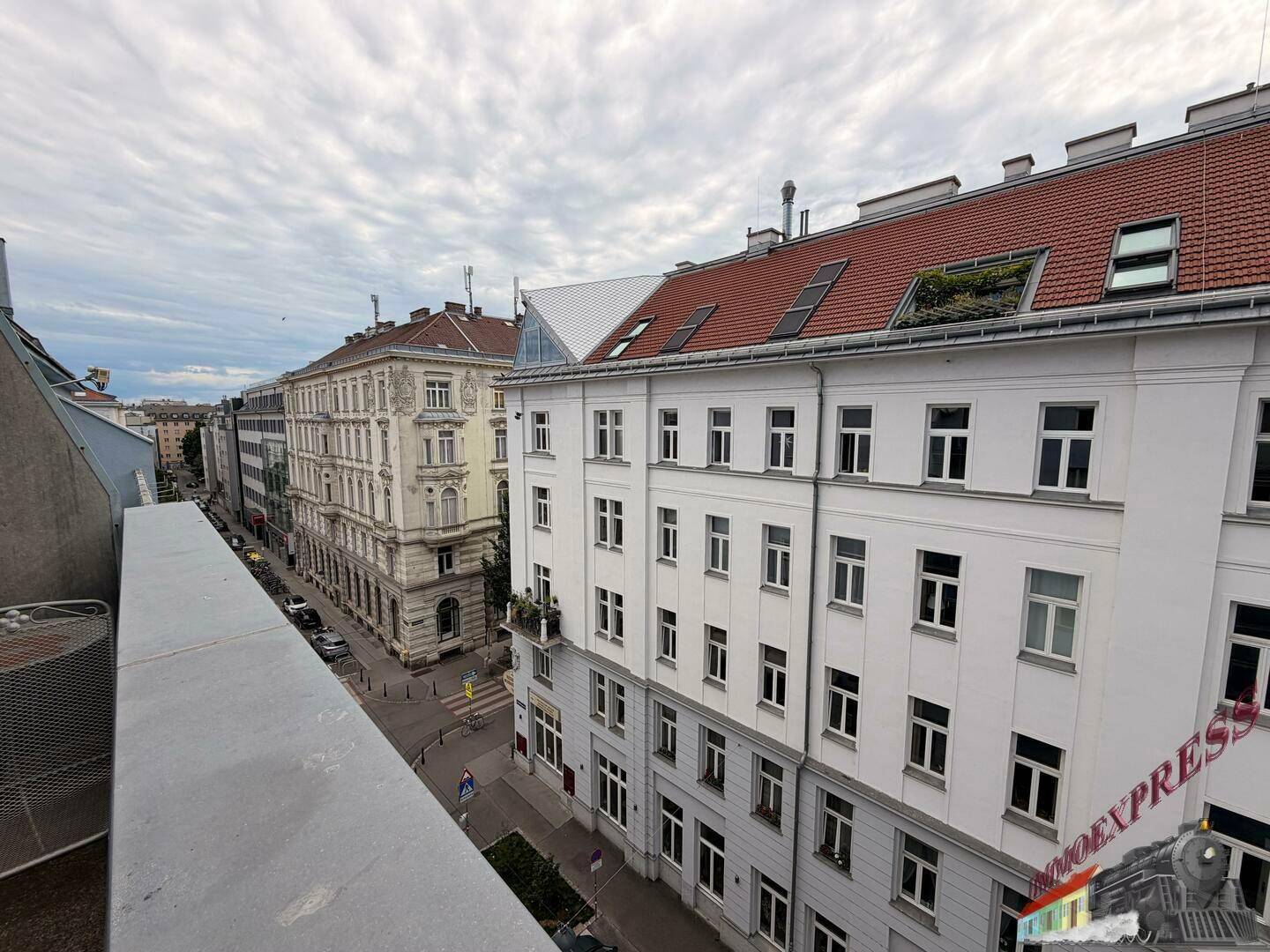 Panoramablick über eine städtische Straße mit traditionellen Gebäuden und bewölktem Himmel.